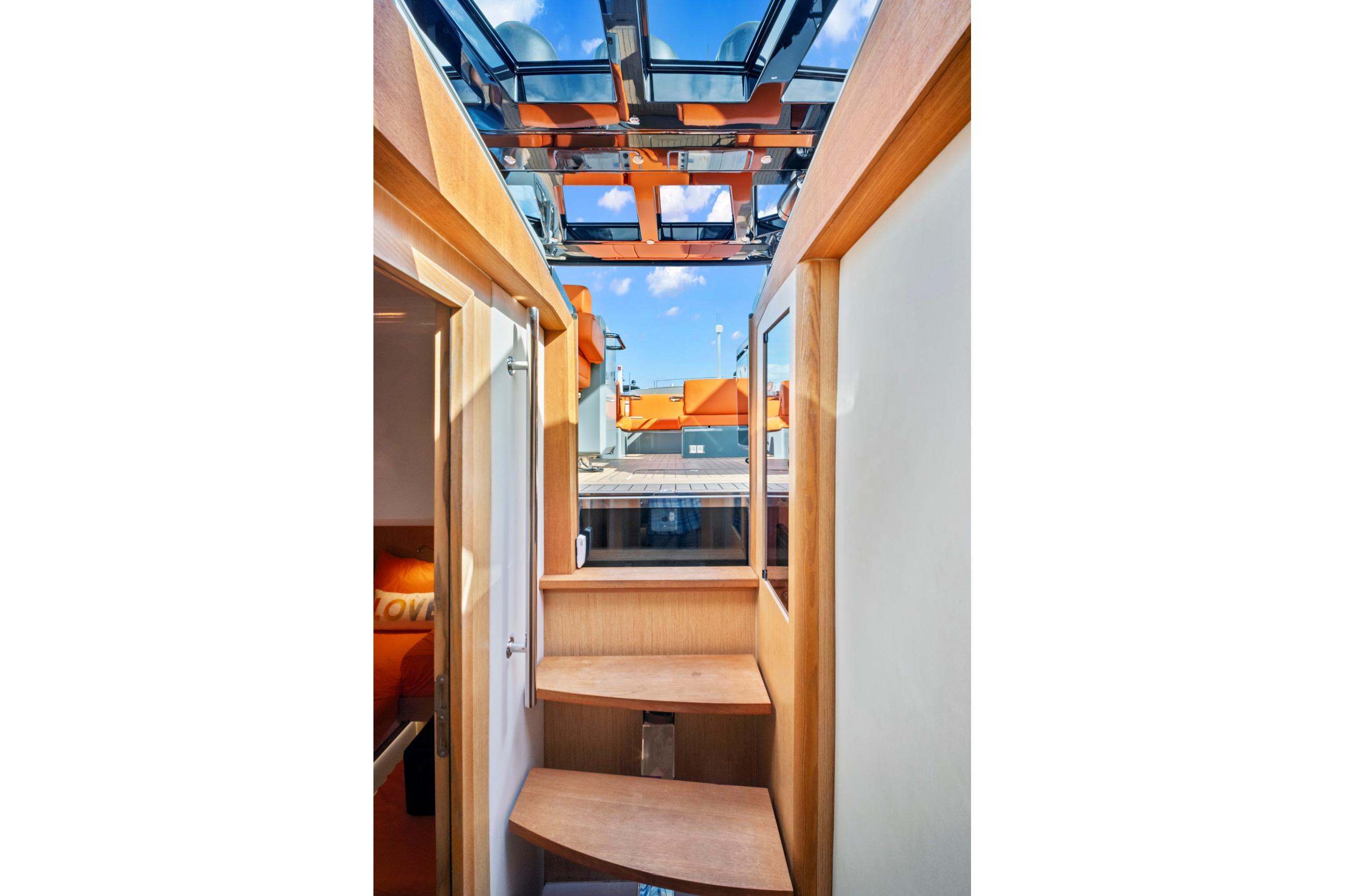 Interior view of 2019 Fjord 52 Open yacht with wooden stairs and glass ceiling.