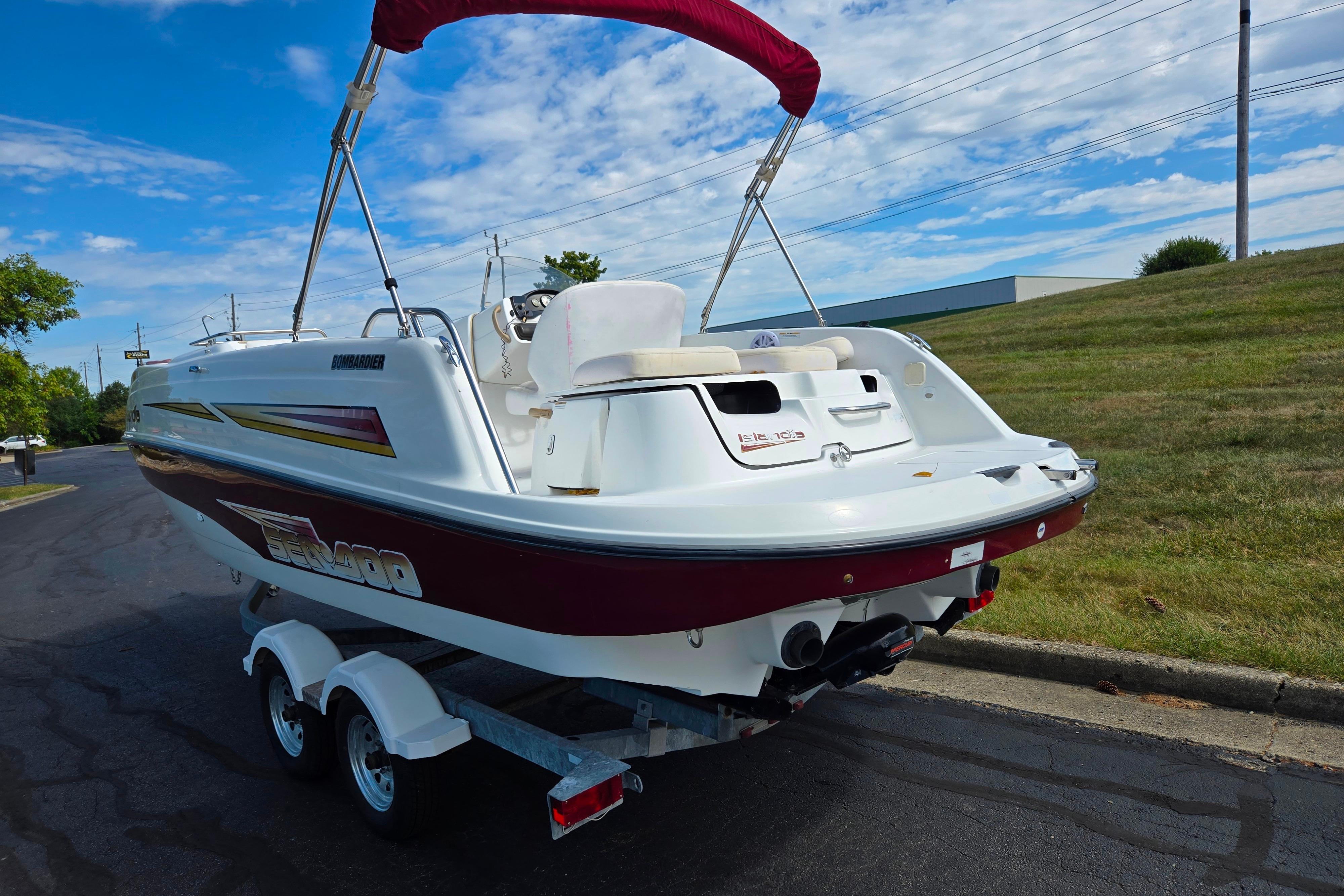 2004 Sea-Doo Islandia boat on trailer, parked on a road with grassy background.