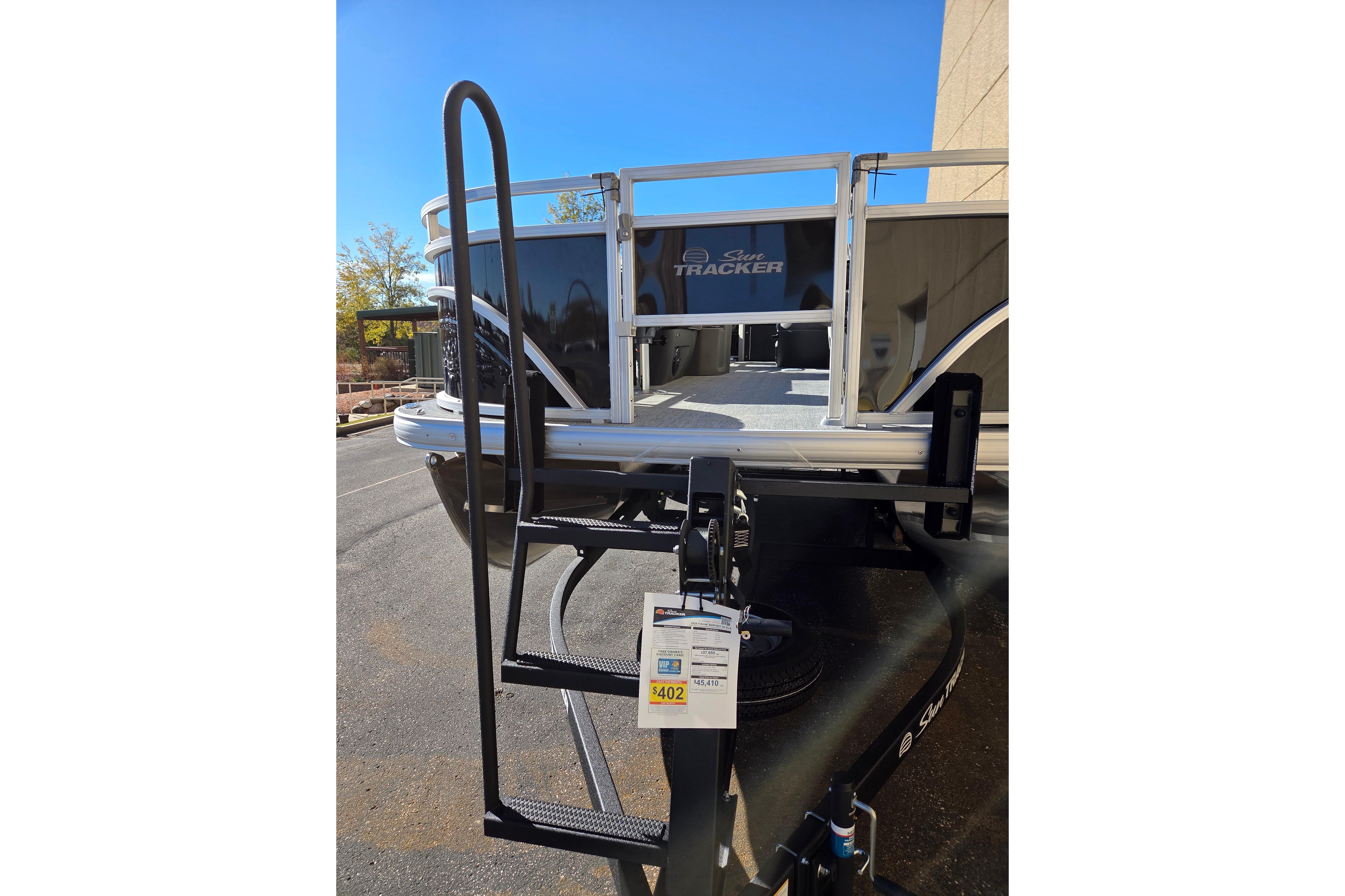 2026 Sun Tracker Fishin' Barge 20 DLX pontoon boat with boarding ladder.