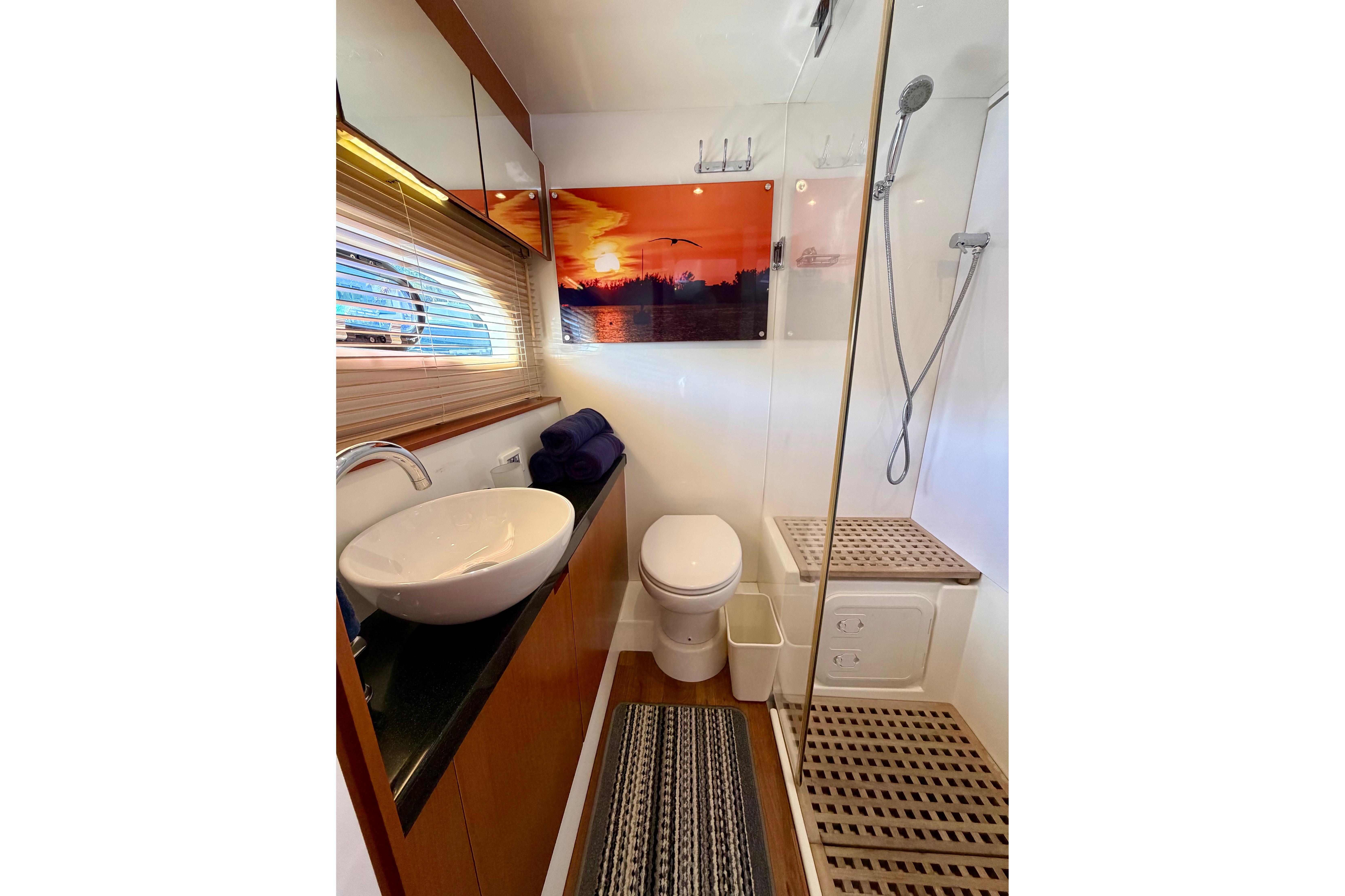 Luxurious bathroom in 2017 Aquila 44 Yacht with modern fixtures and sunset artwork.