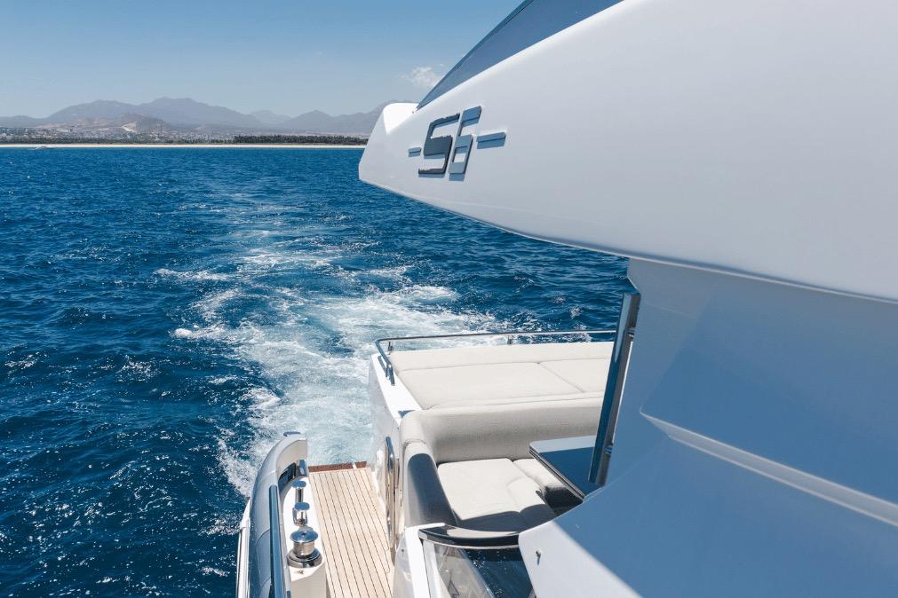 Azimut 60 yacht cruising on blue ocean, 2020 model, with scenic mountain backdrop.