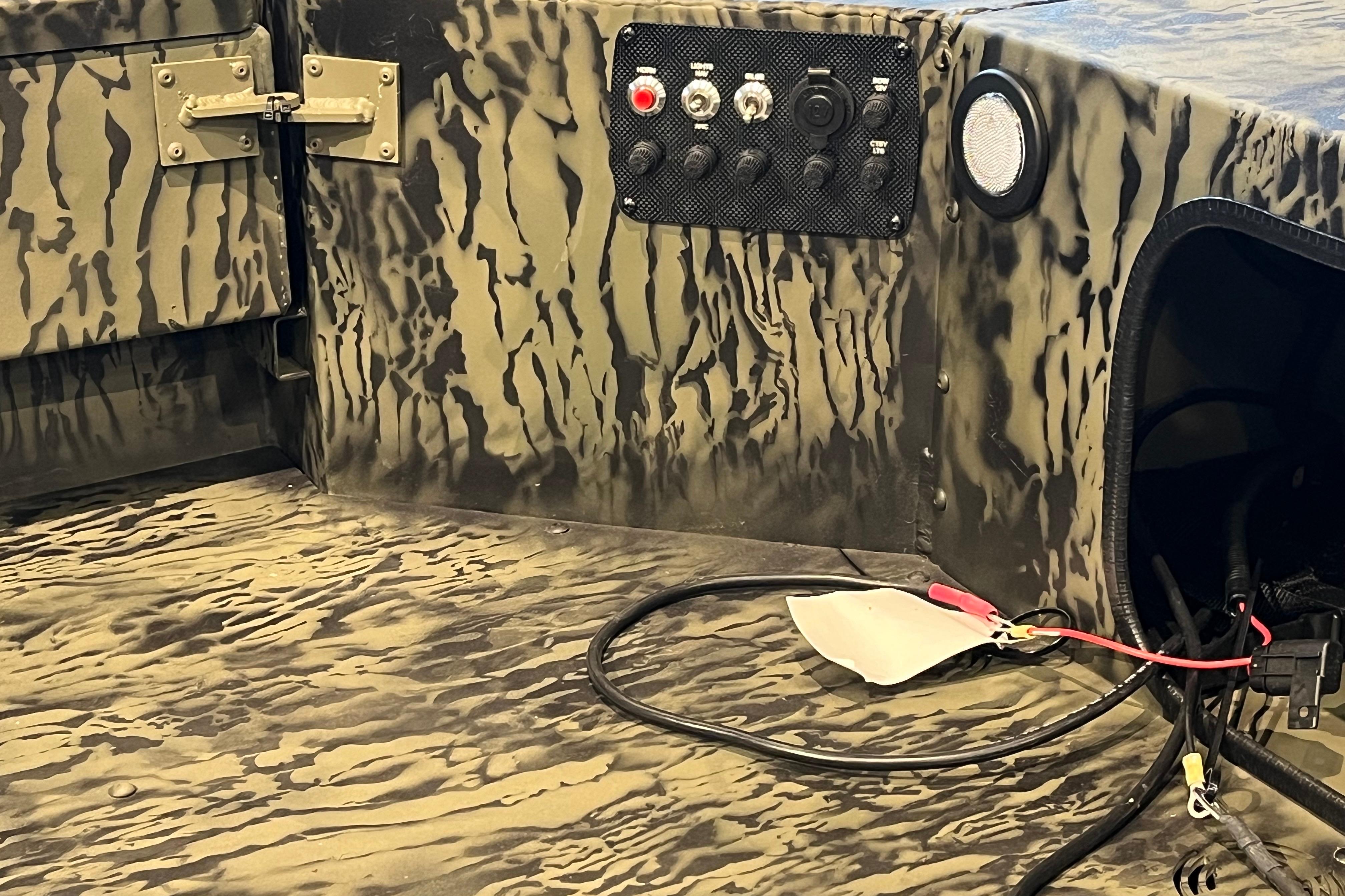 Interior of 2026 Tracker Grizzly 1654 T Sportsman boat with camouflage design and control panel.