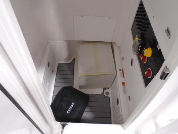 Interior view of 2025 Caymas 26 HB boat compartment with control panel and storage.