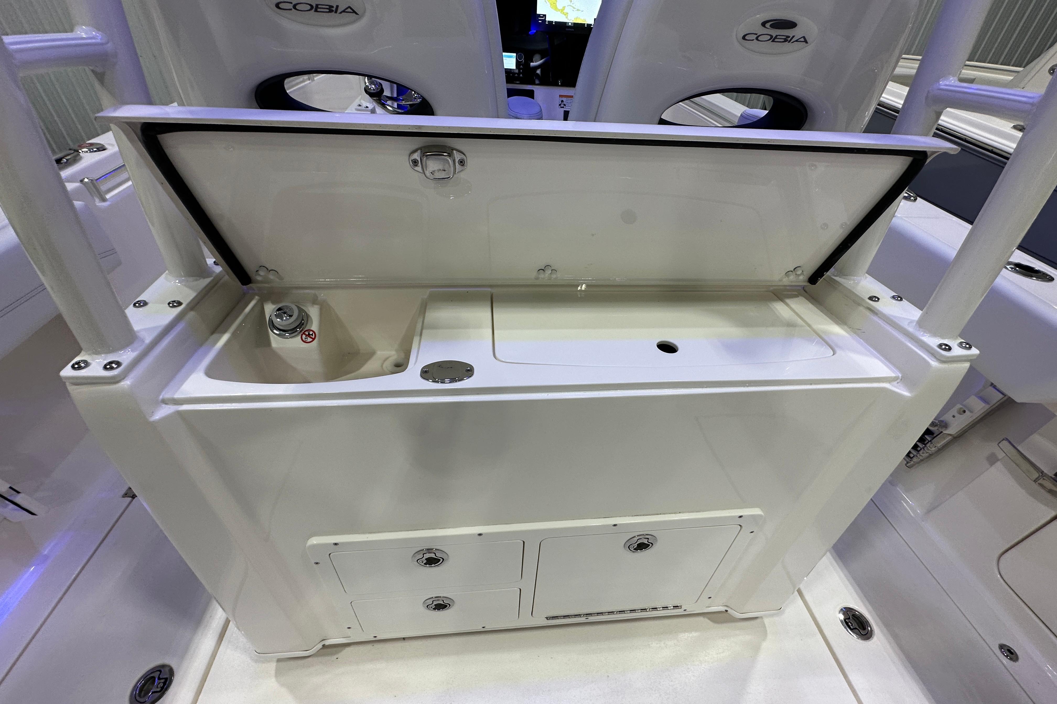 2024 Cobia 301 Center Console boat with open storage compartment and seating.