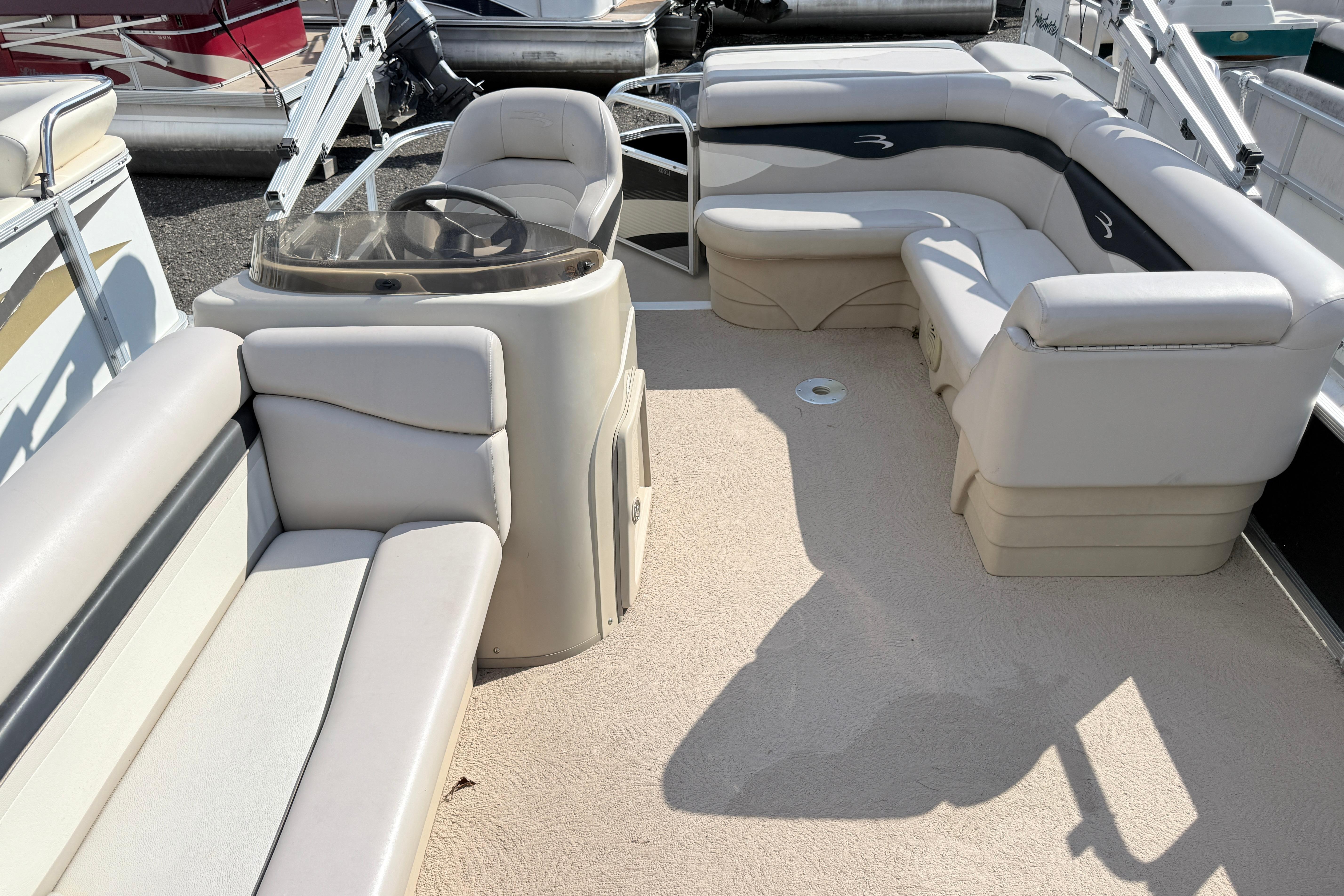 2010 Bennington 20SLi pontoon boat interior with beige seating and steering console.