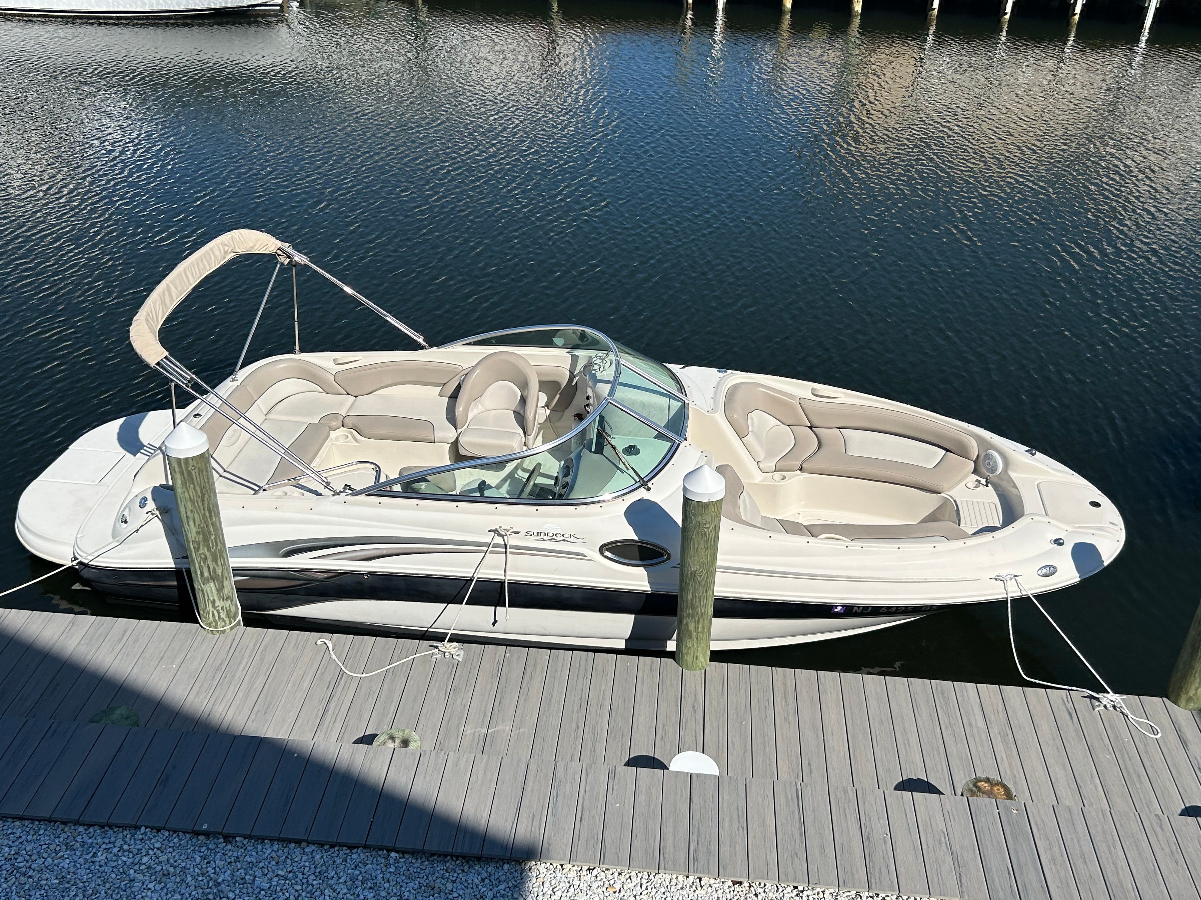 2003 Sea Ray 240 Sundeck at dock, calm water.