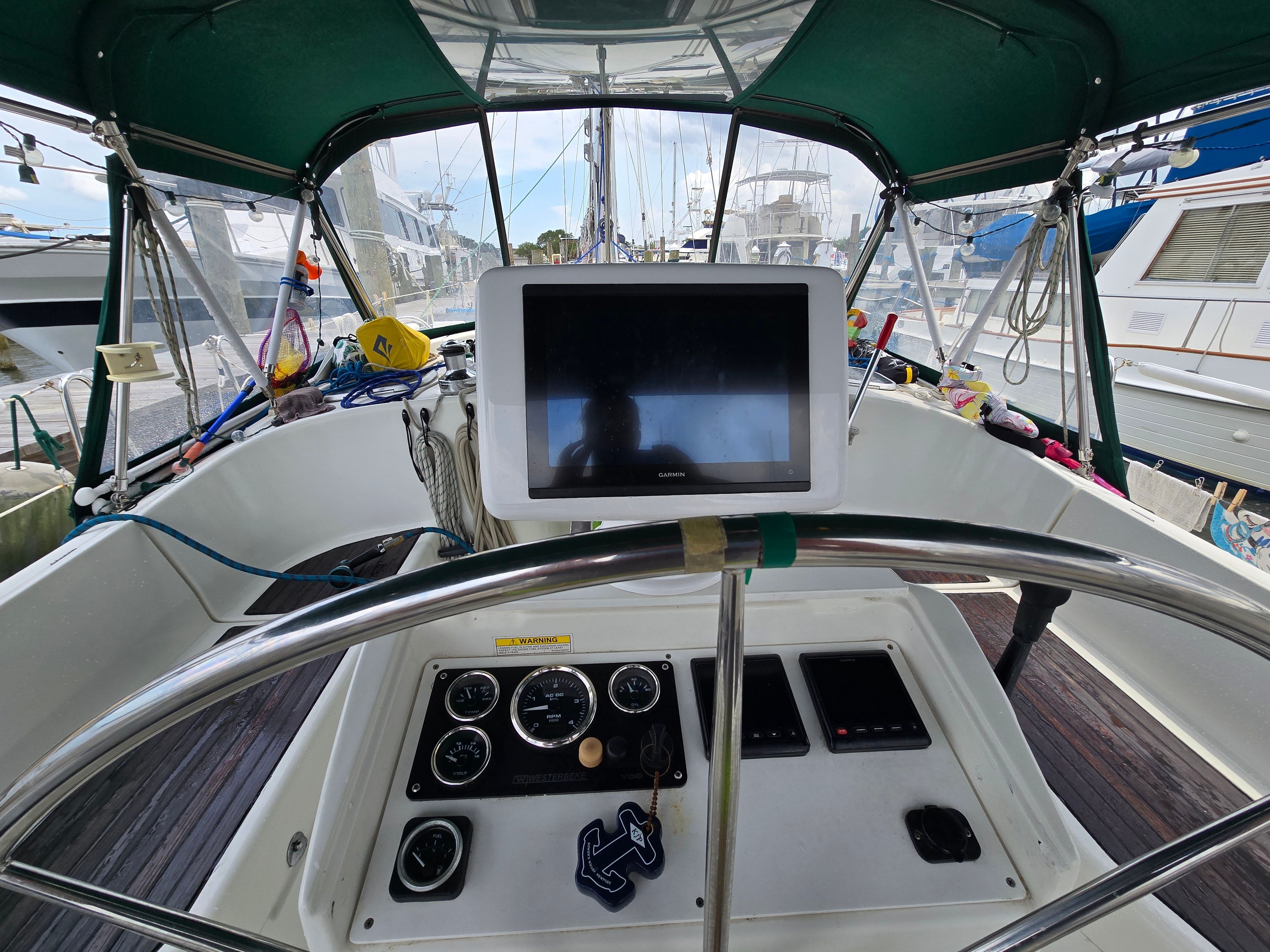 The cockpit of a 1998 Beneteau 411 with a steering wheel and navigation screen.