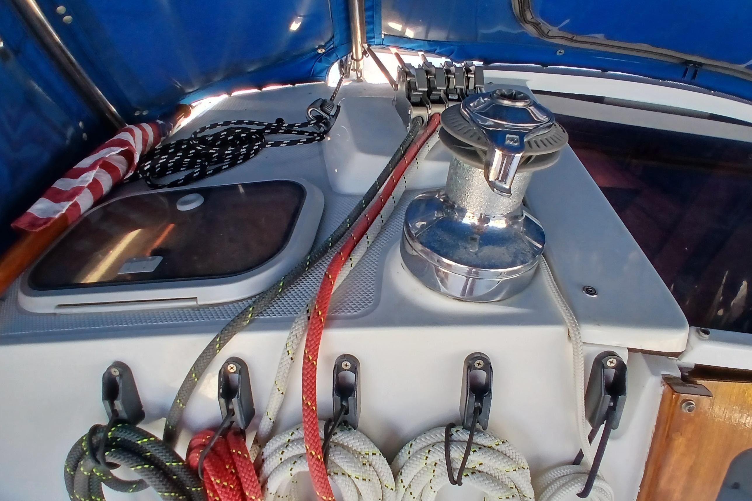 Cockpit of 1995 Catalina 42 MkII sailboat with winch and ropes under blue canopy.