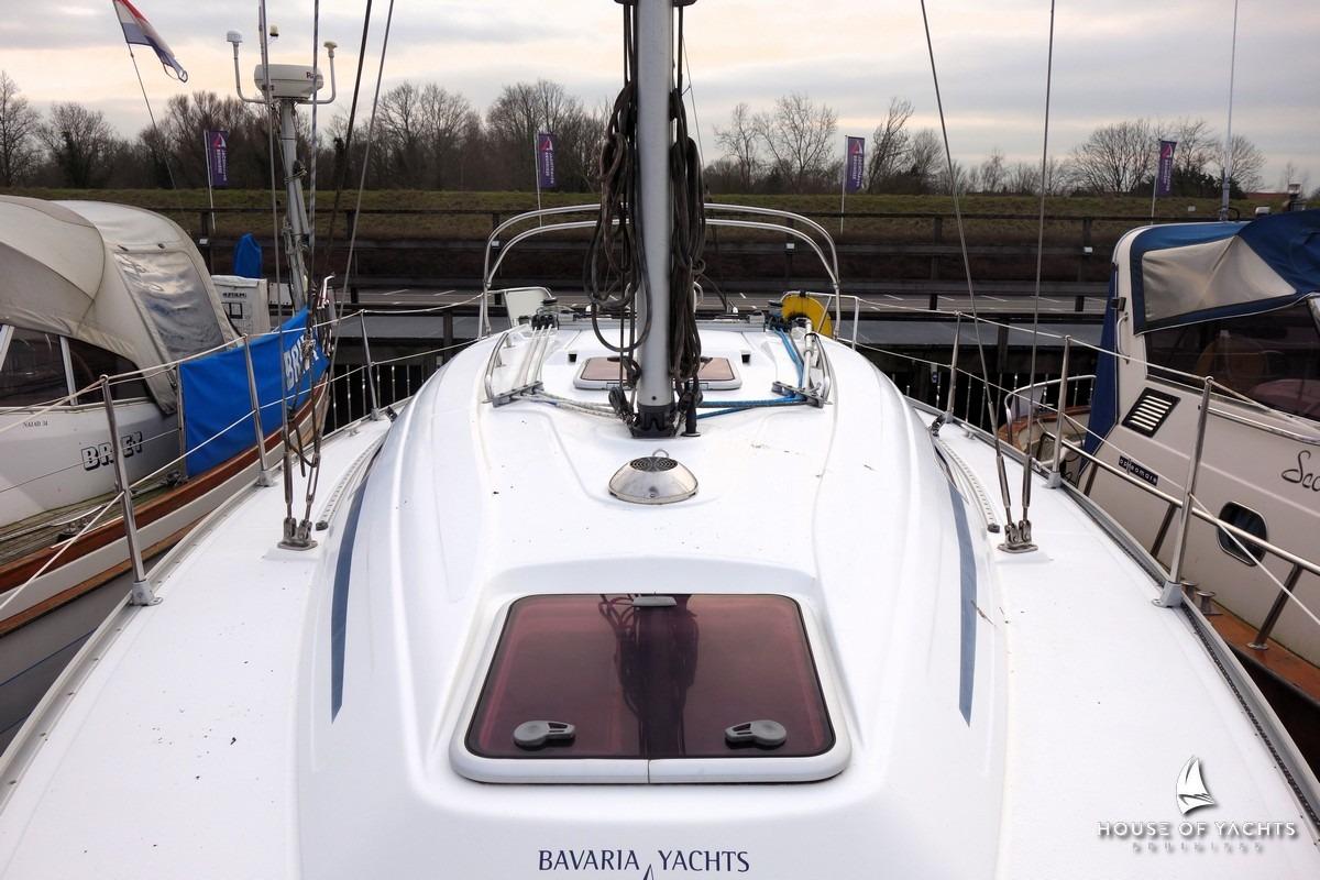 2003 Bavaria 32 yacht docked, showcasing sleek deck design and marina surroundings.