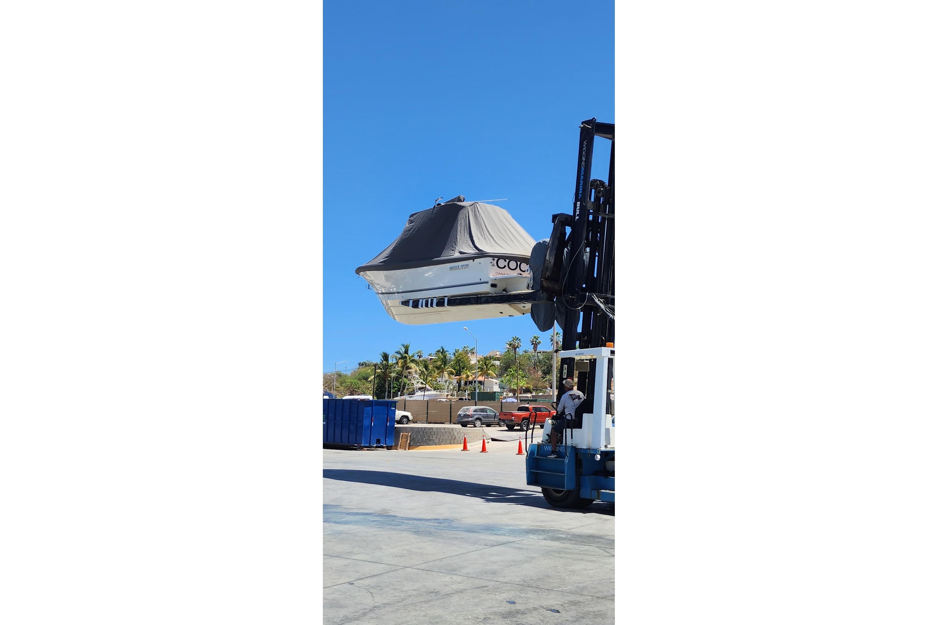 2022 Regulator 28 boat being lifted by a forklift at a marina.