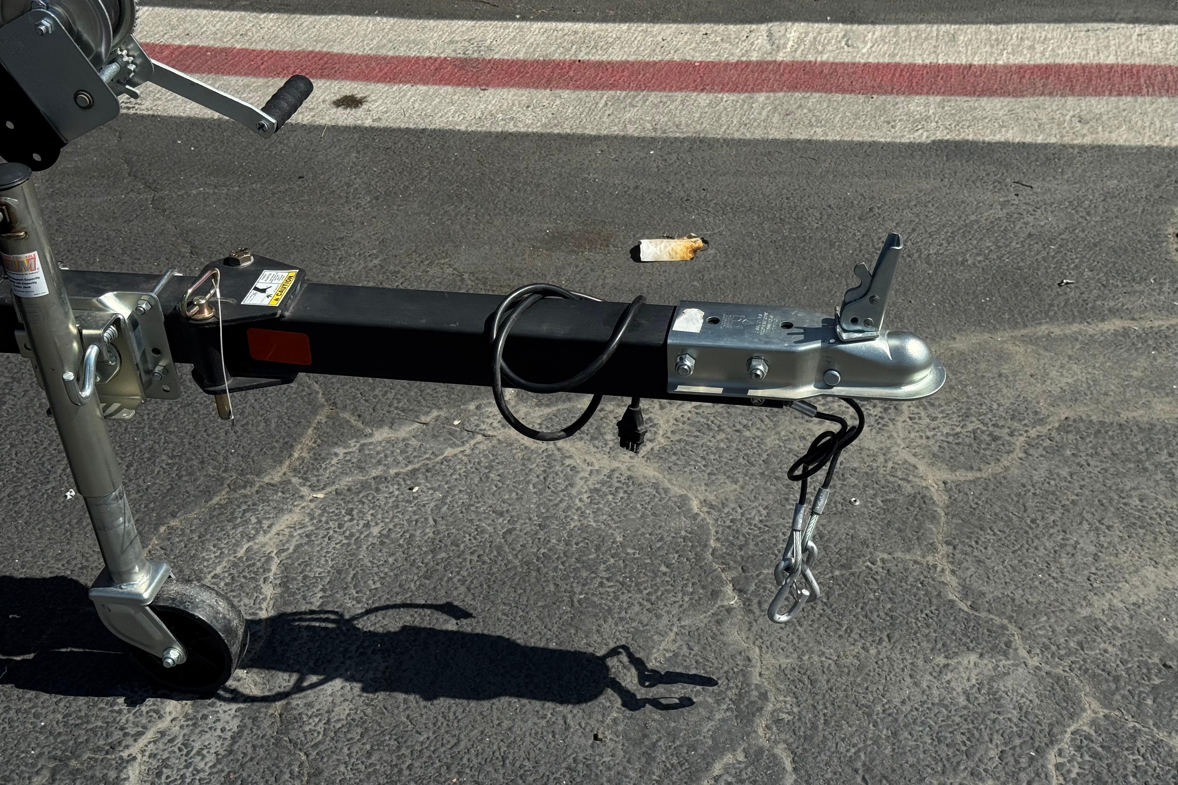Trailer hitch of a 2024 Lowe Stinger 175 on asphalt pavement.