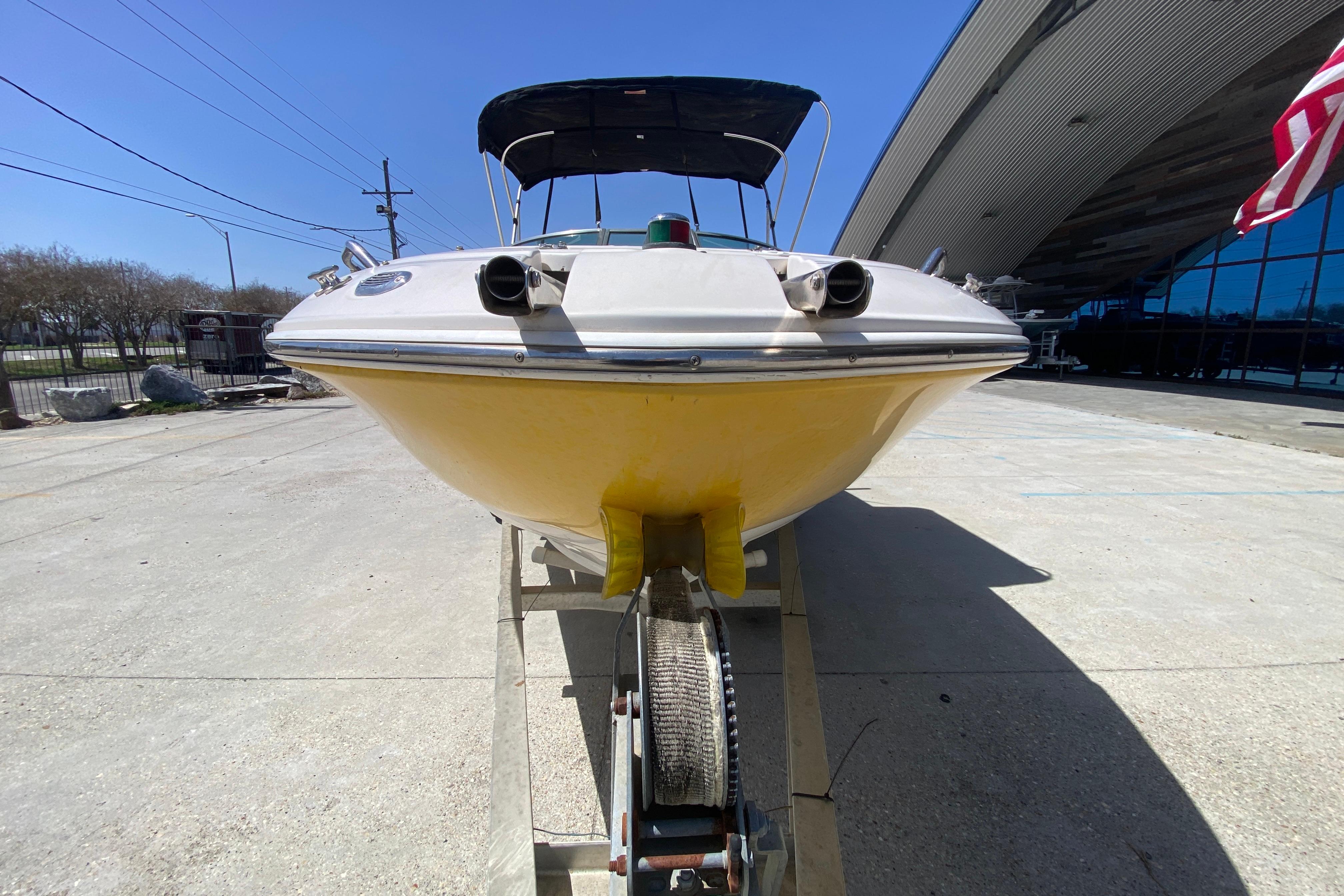 2003 Monterey 208SI Montura boat on trailer, yellow hull, outdoor display.