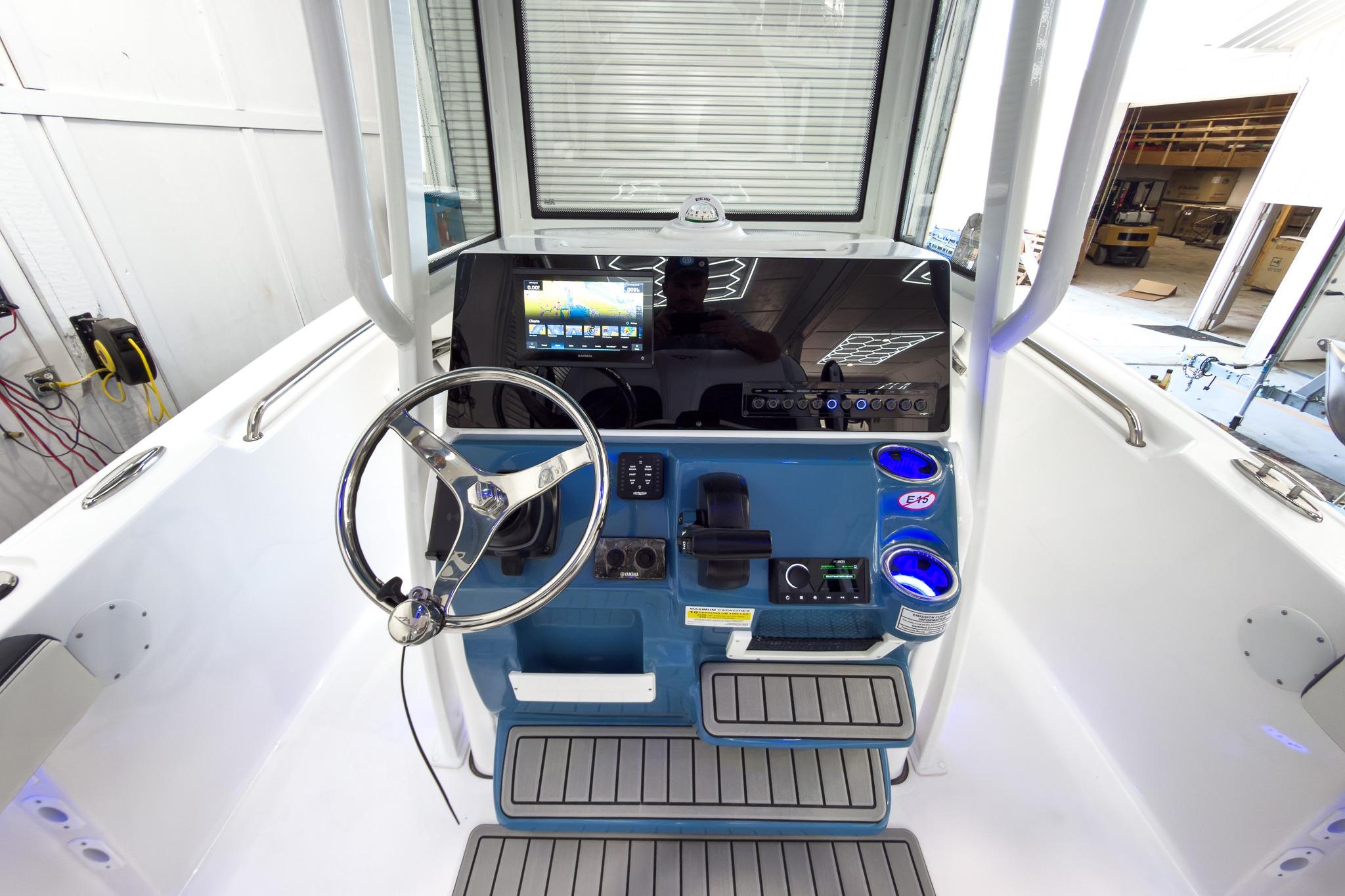 The image shows the cockpit of a Tidewater 220 LXF boat with a modern helm station.