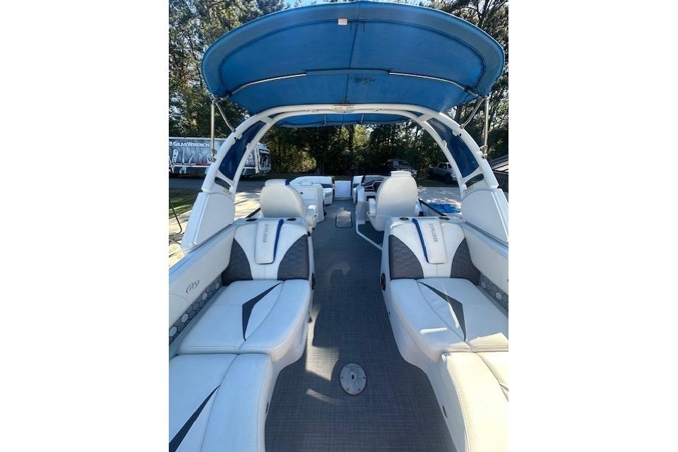 2020 Manitou 25 X-Plode RFW pontoon boat interior with blue canopy and white seating.