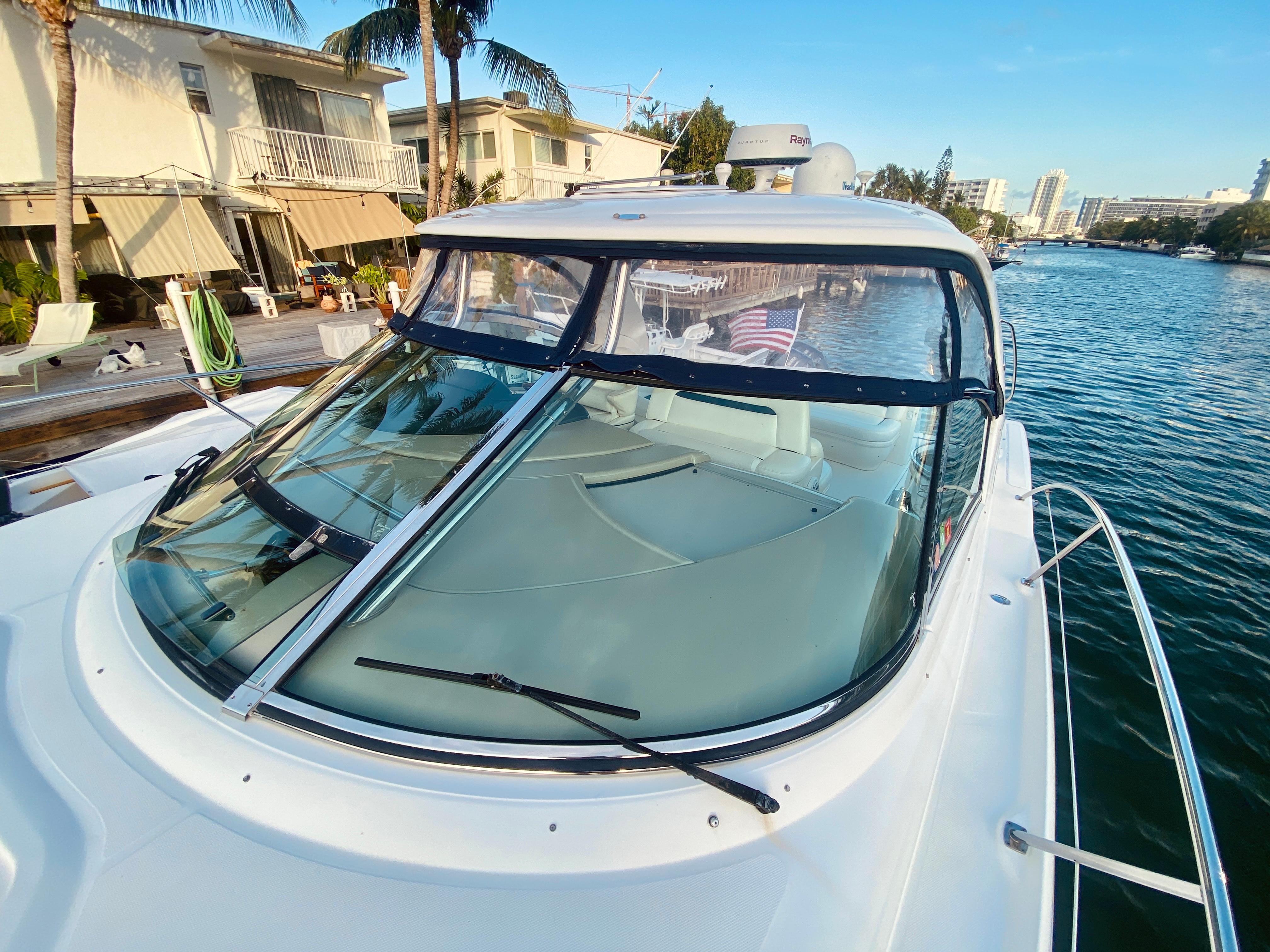 2005 Sea Ray 420 Sundancer yacht docked by waterfront homes.