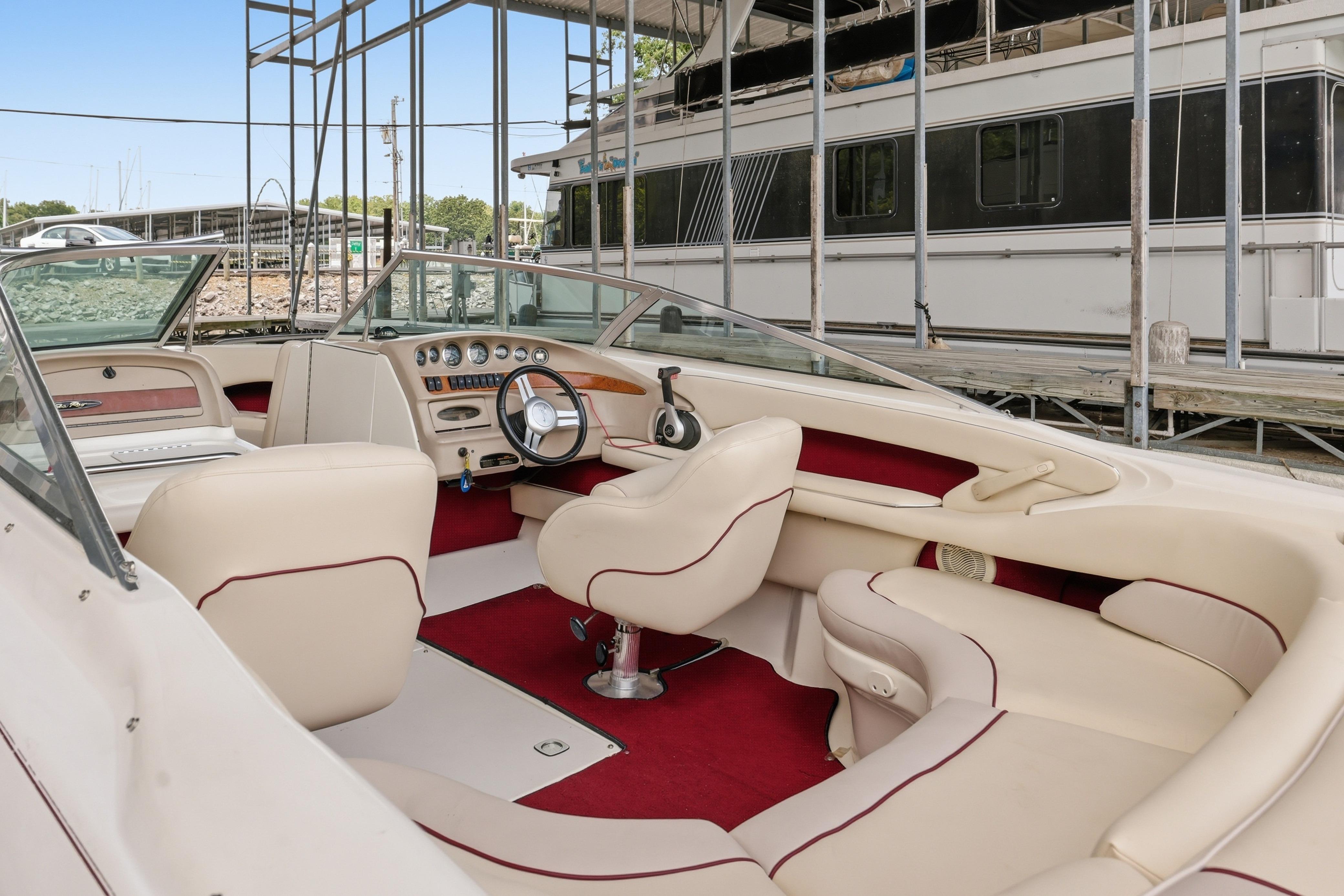 1997 Sea Ray 230 Signature boat interior with cream and red upholstery, docked at marina.