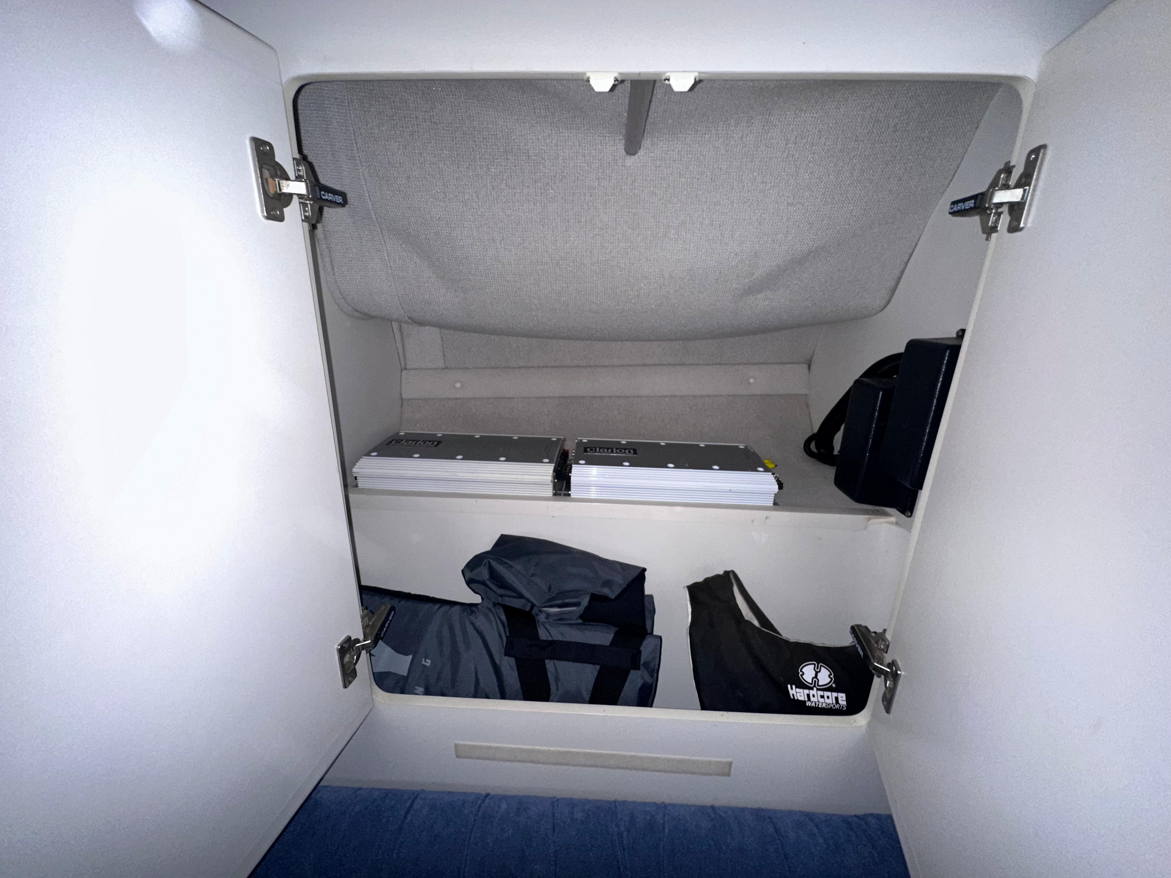 Storage compartment inside a 1994 Carver 340 Santego boat, featuring organized shelves and bags.