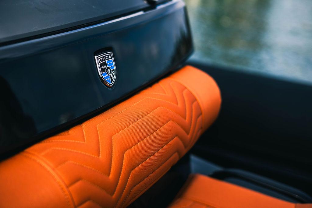 2025 Onda Magna interior with orange upholstery and logo detail.
