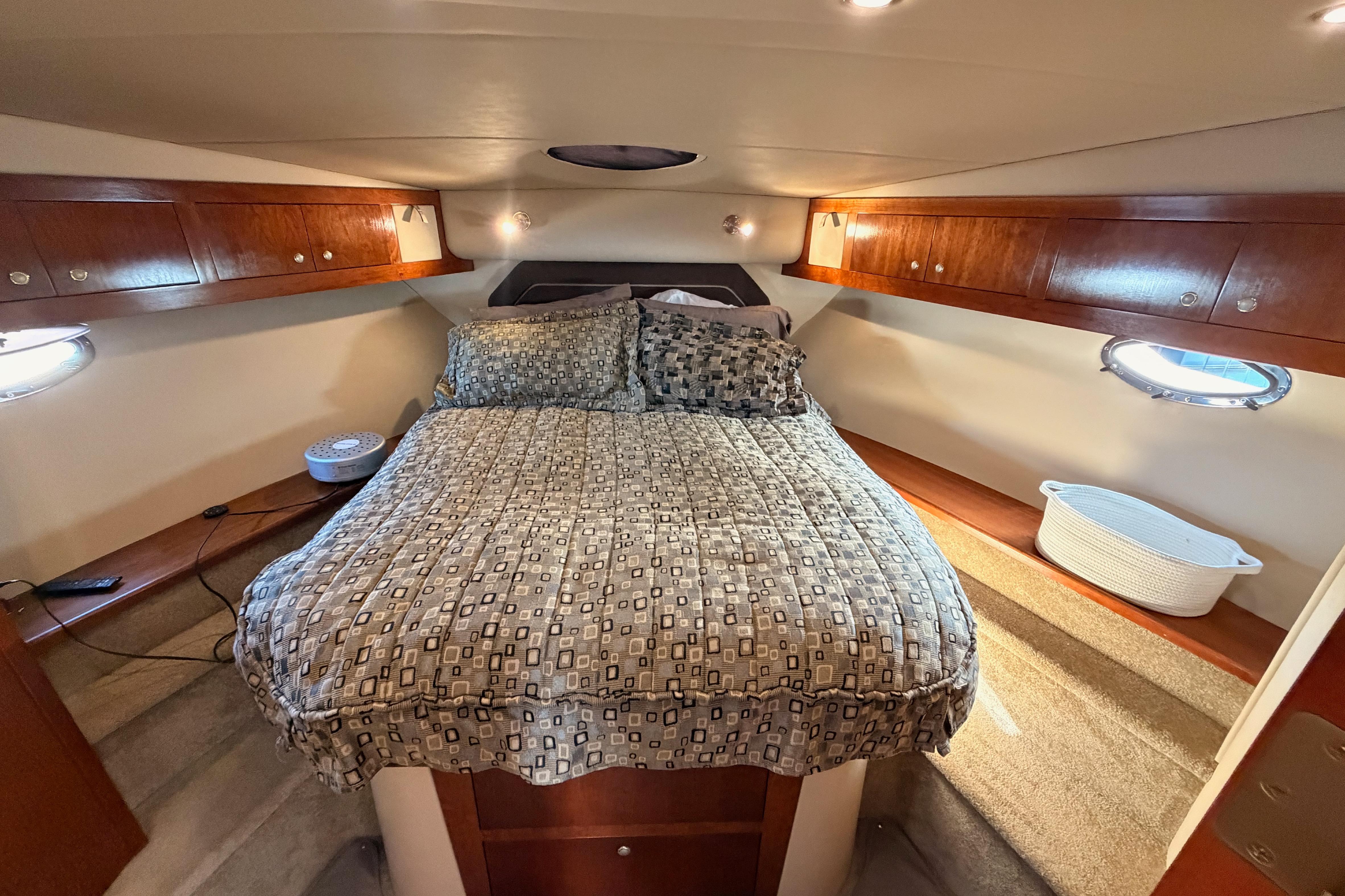 Luxurious bedroom interior of 2005 Cruisers Yachts 405 Express Motoryacht with cozy bedding.