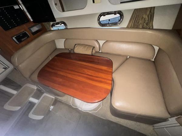 2005 Four Winns 298 Vista cabin with beige seating and wooden table.