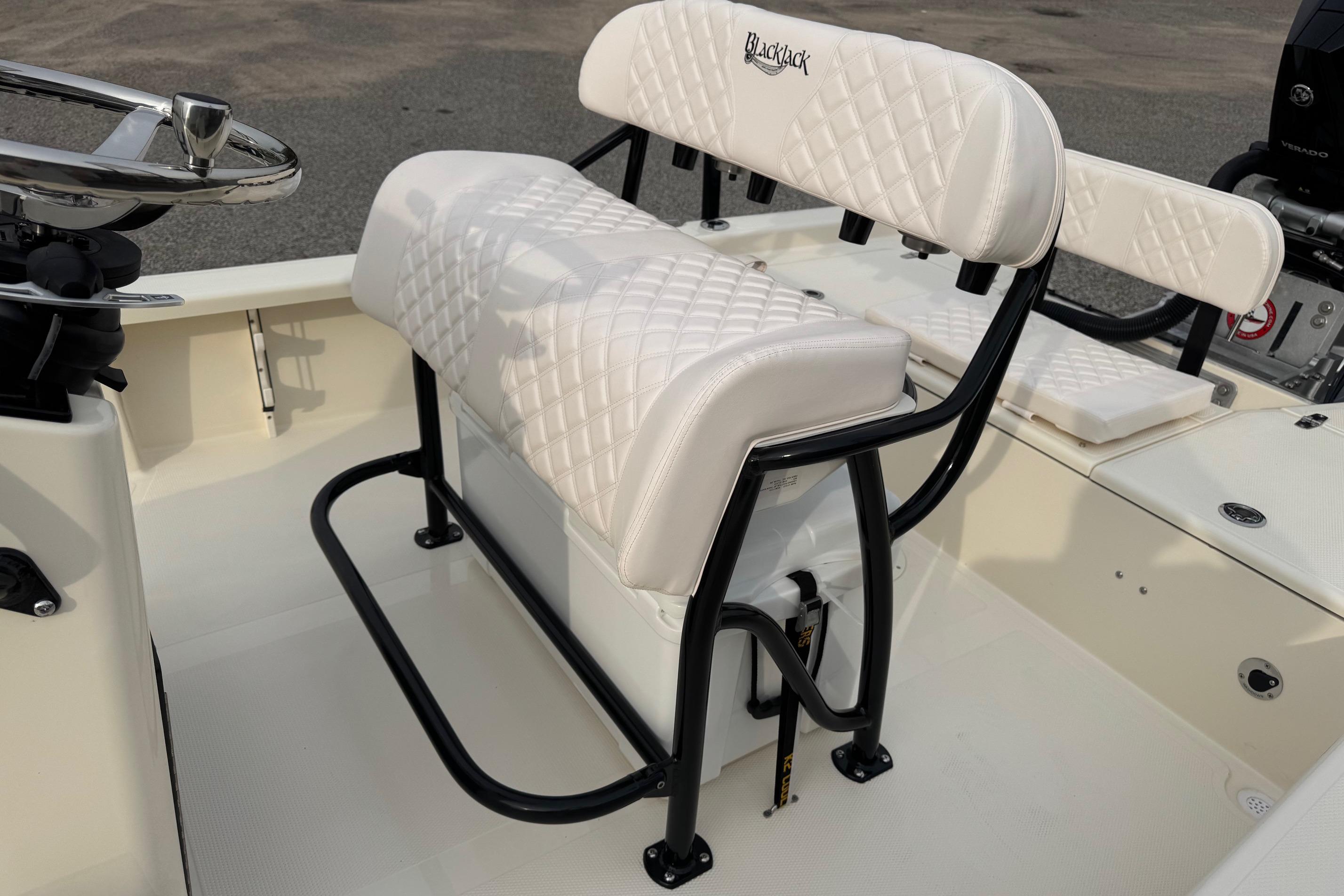 White cushioned seating on 2026 BlackJack 224 boat, featuring sleek black frame design.