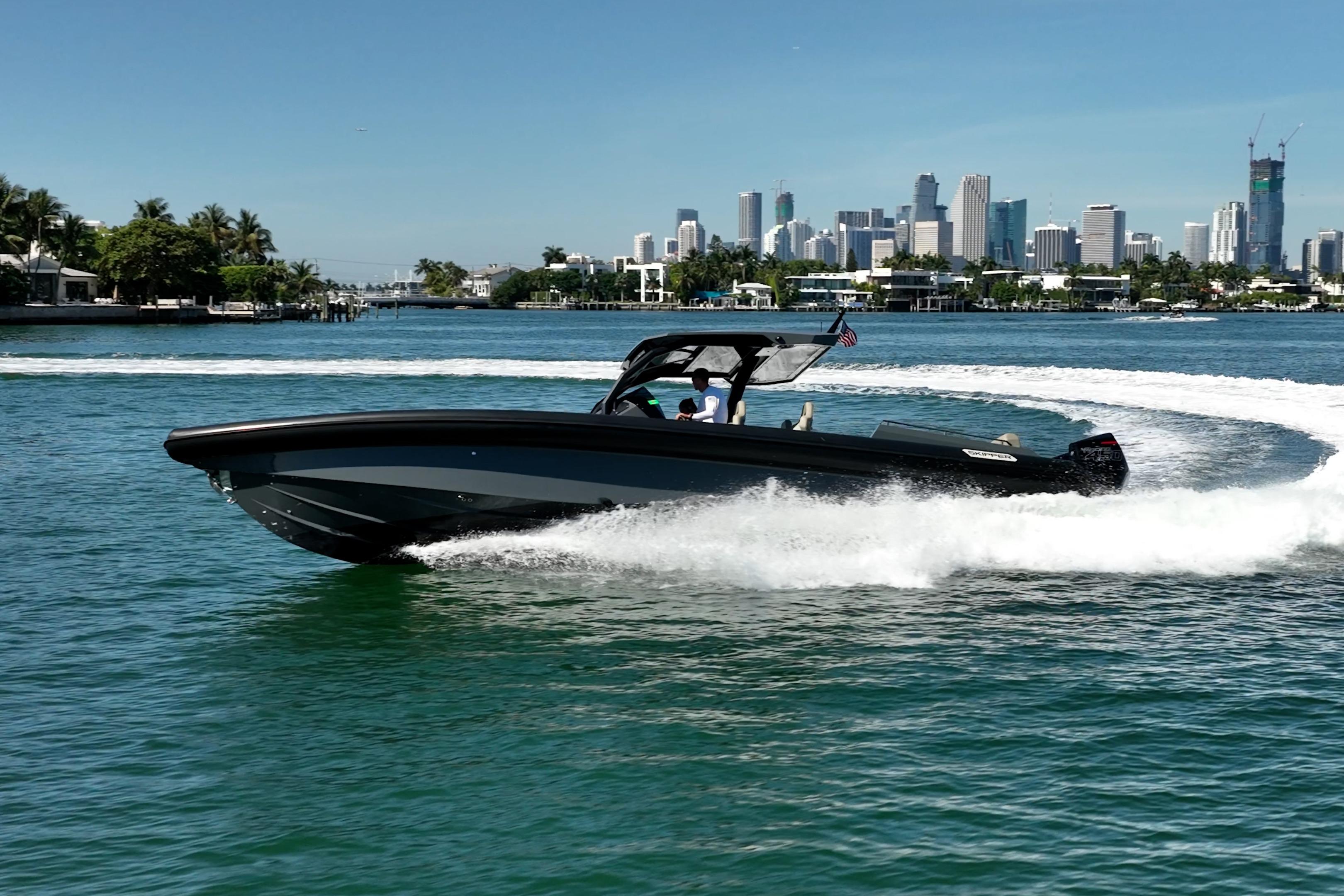 2023 Skipper-BSK 38NC boat cruising in a scenic waterfront cityscape.