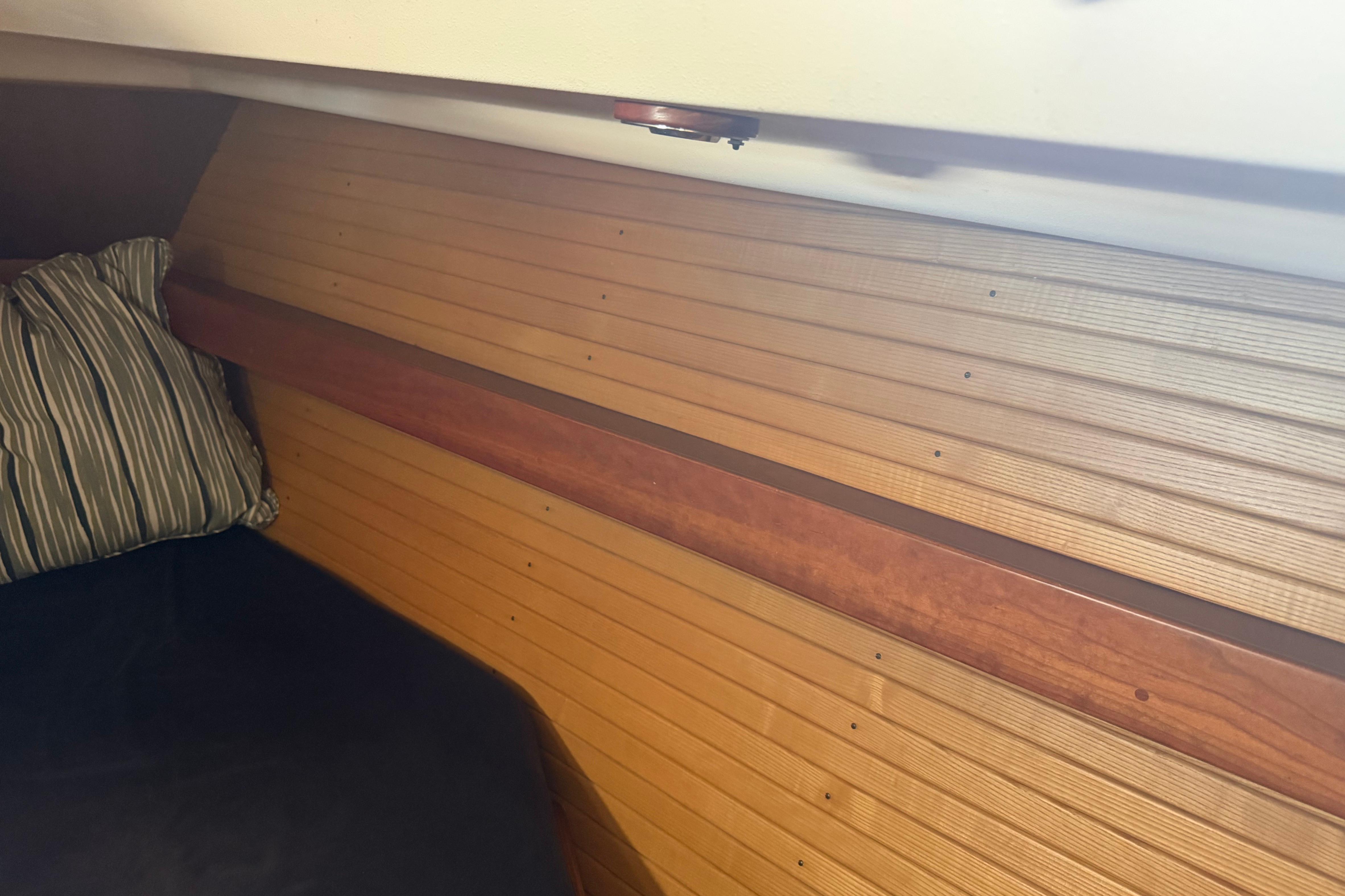 Interior cabin of 2004 Sabre 386 sailboat with wood paneling and striped pillow.