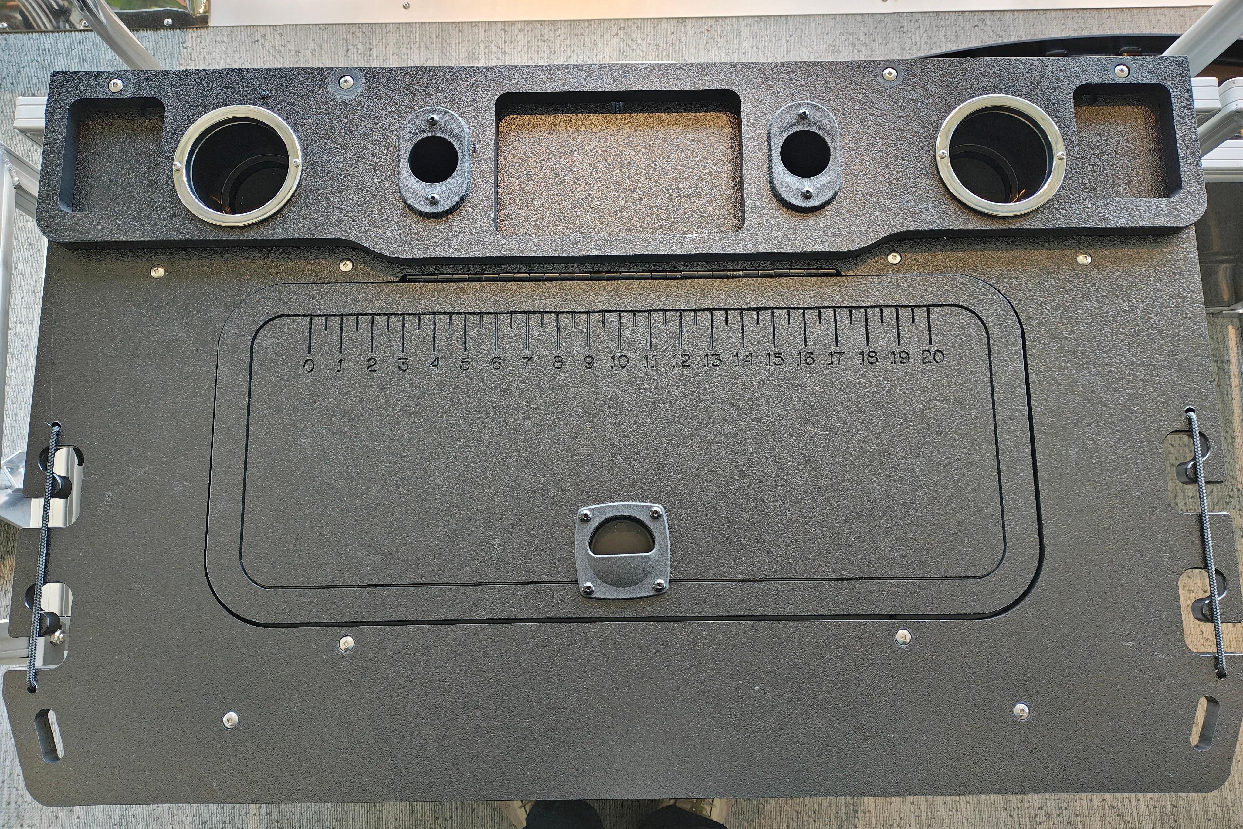 Control panel of 2026 Sun Tracker Fishin' Barge 22 XP3 with cup holders and measurement markings.
