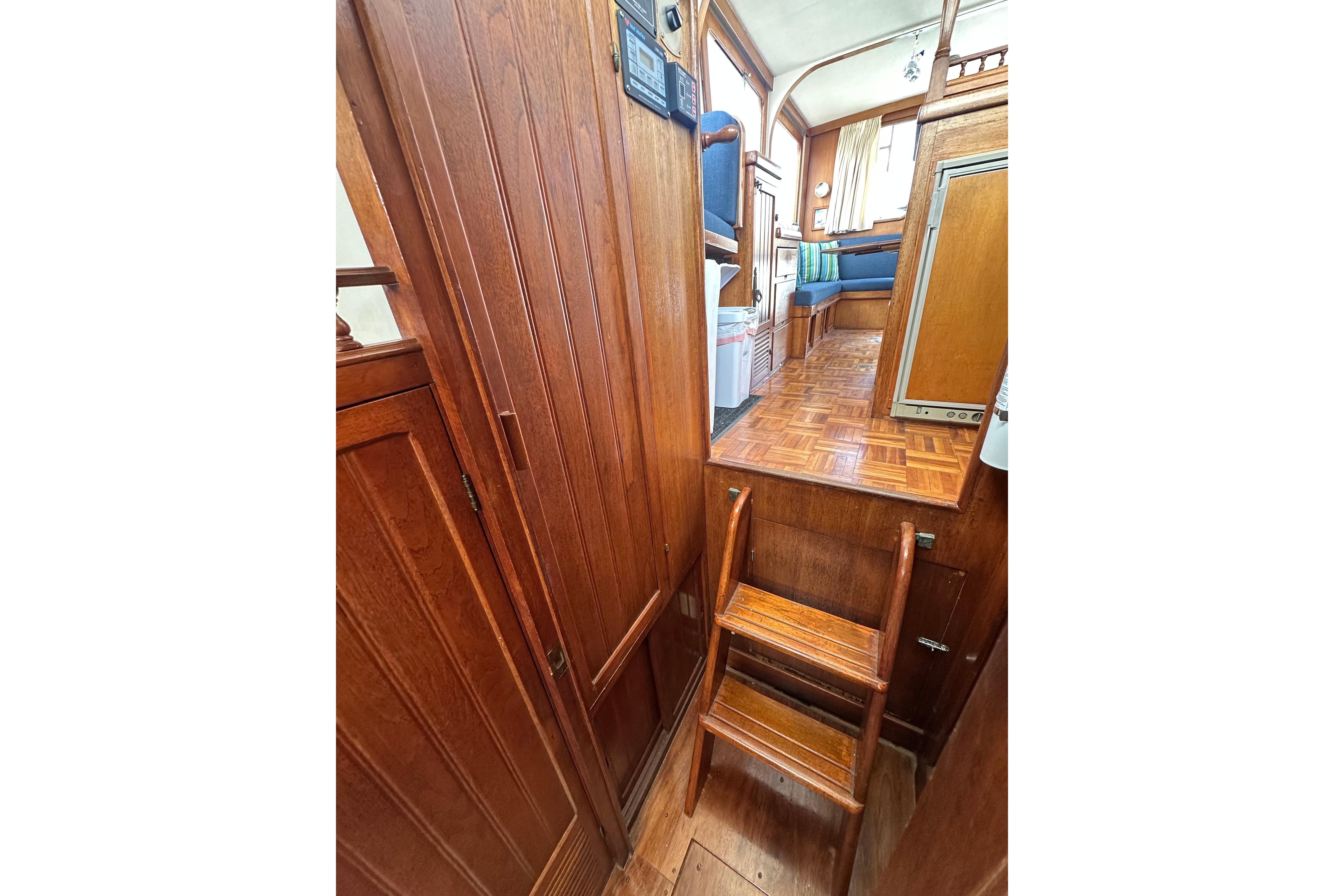 Interior of a 1973 CHB 33 boat featuring wooden stairs and seating area.