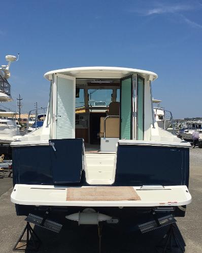 2026 Back Cove 372 yacht, rear view, docked under clear blue sky.