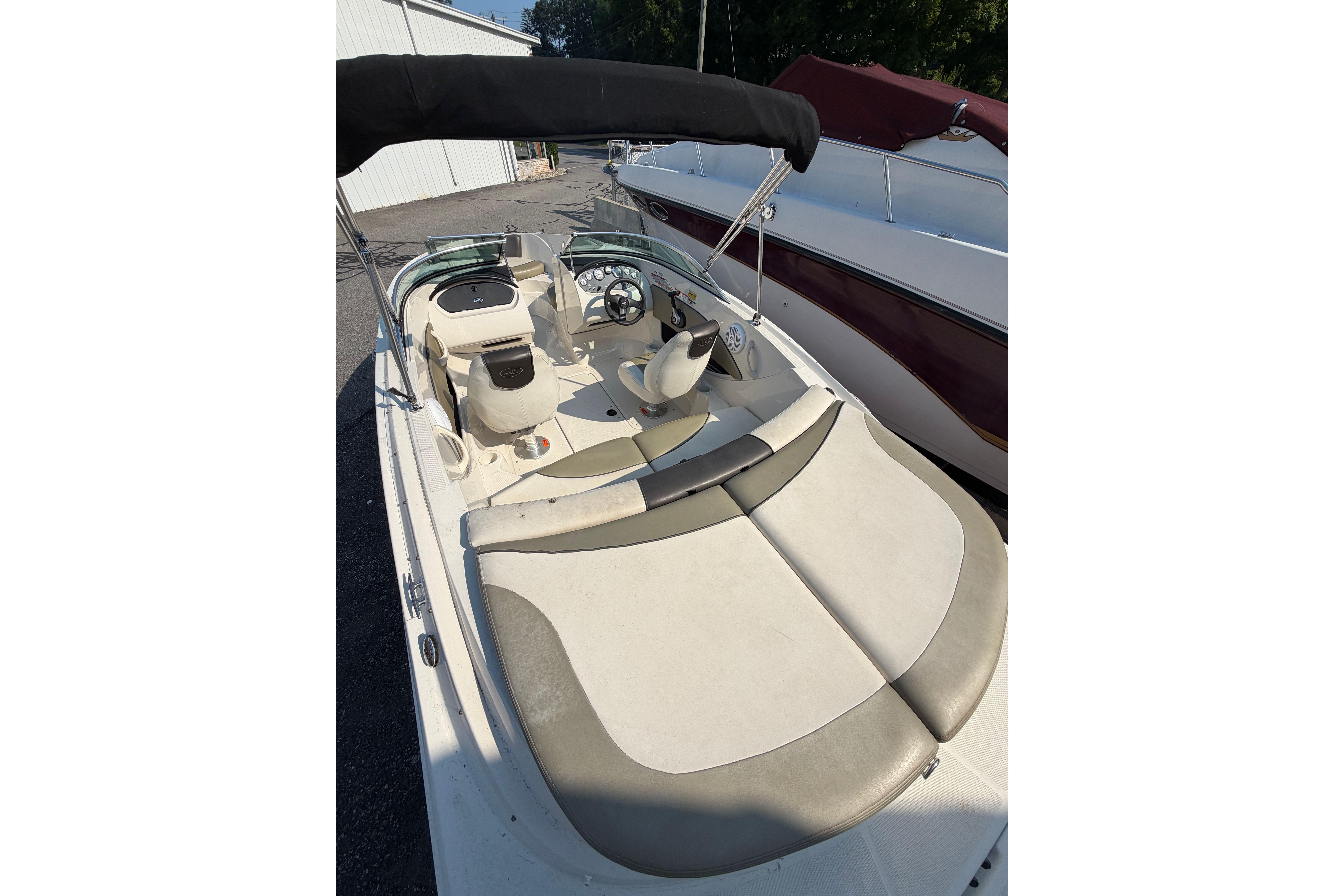 2006 Sea Ray 195 Sport boat interior with seating and steering wheel, under a black canopy.