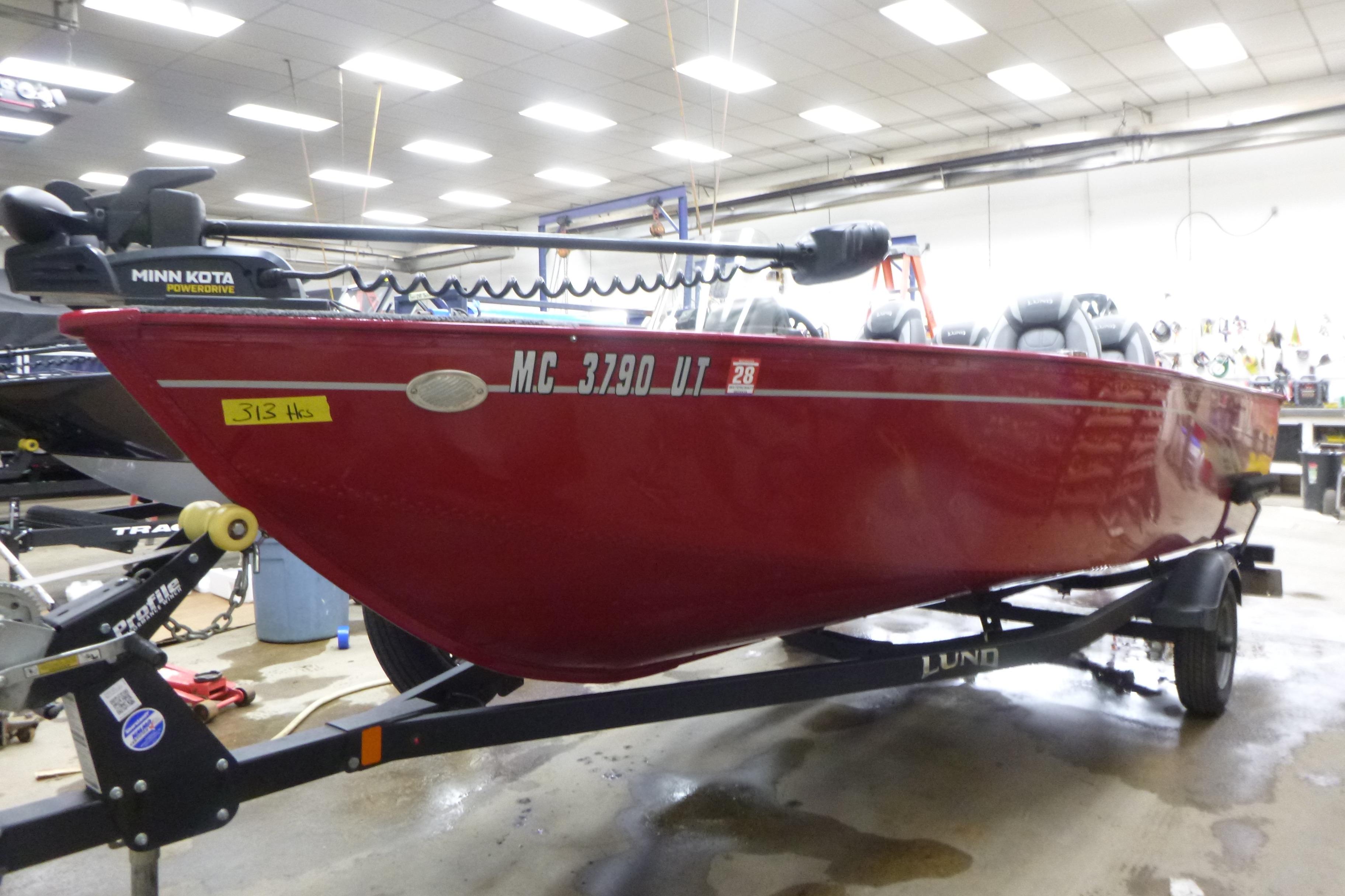 2022 Lund 1650 Angler Sport boat in showroom, red exterior, on trailer.