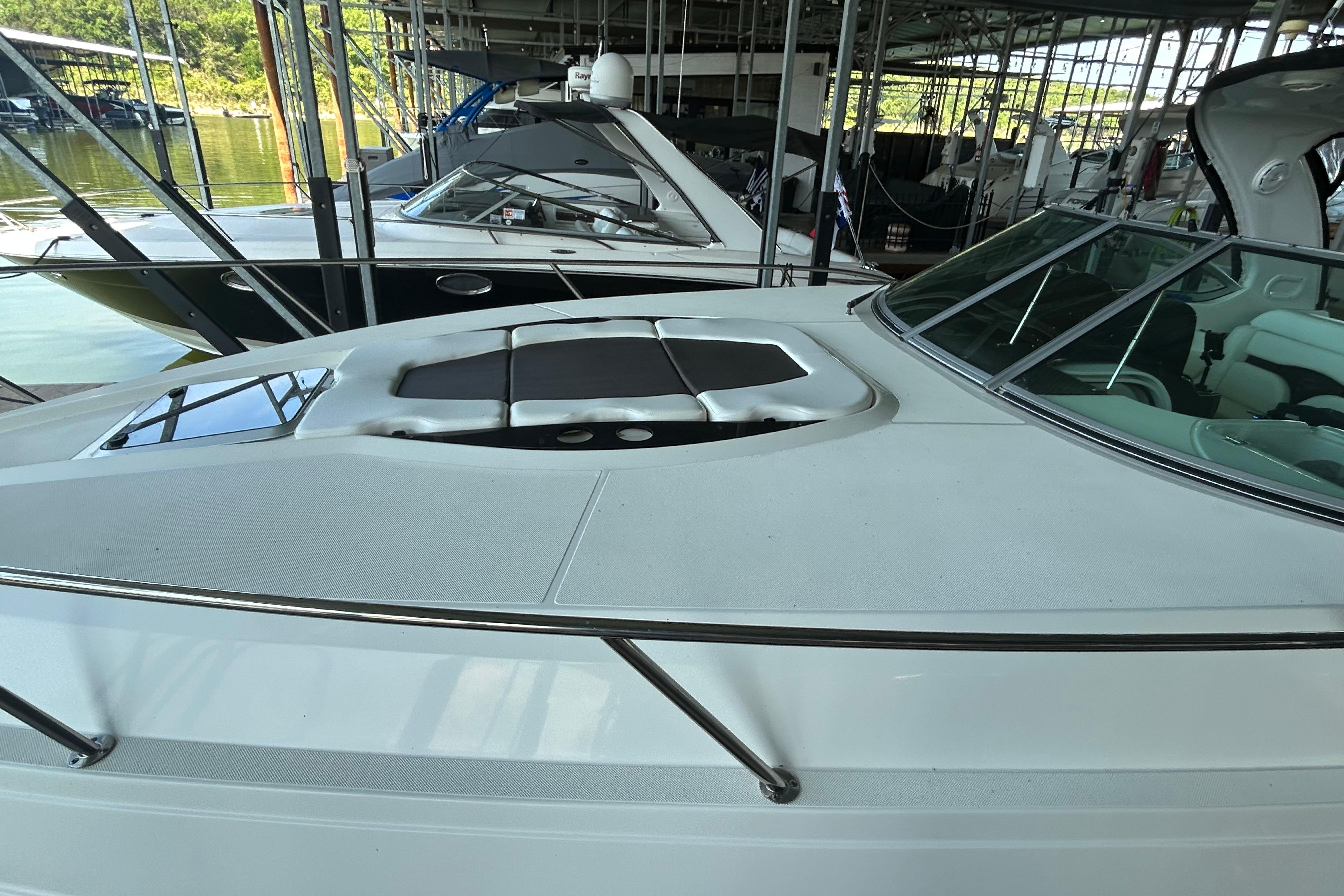 2013 Rinker 310 Express Cruiser docked in a marina, showcasing sleek design and spacious deck.