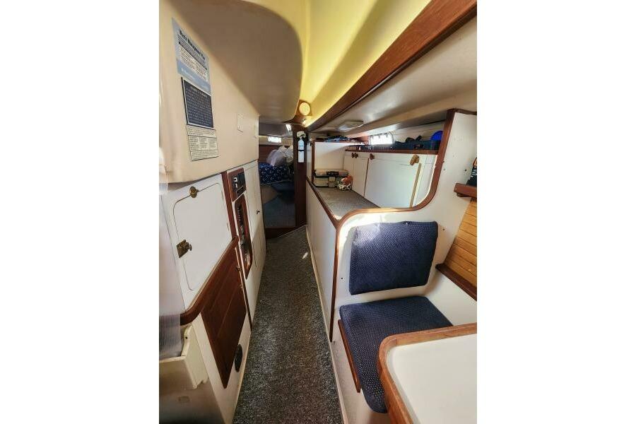 Interior of a 1990 Morgan Classic 41 yacht, featuring cozy seating and wooden accents.