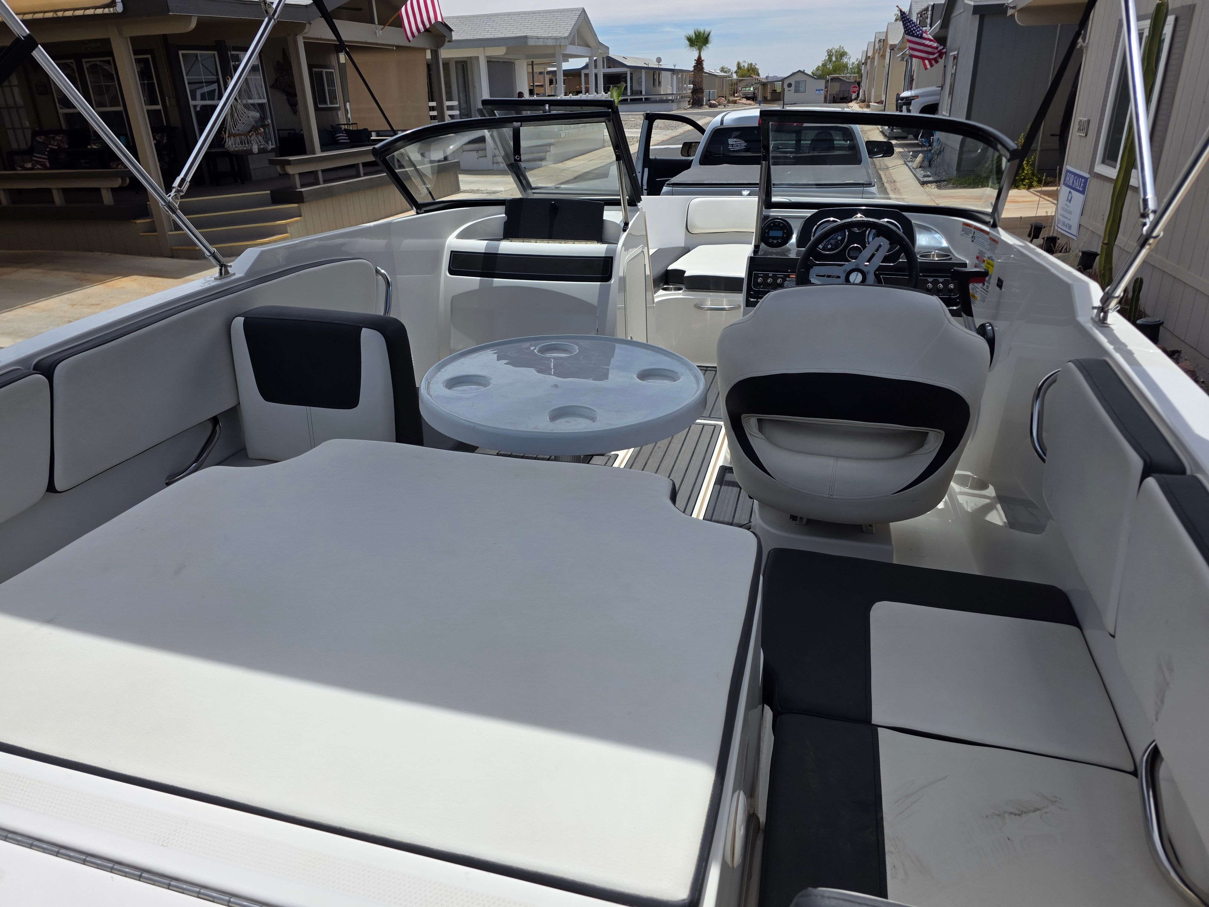 The image shows the cockpit of a 2021 Bayliner VR4 Bowrider I/O with modern seating and a table.
