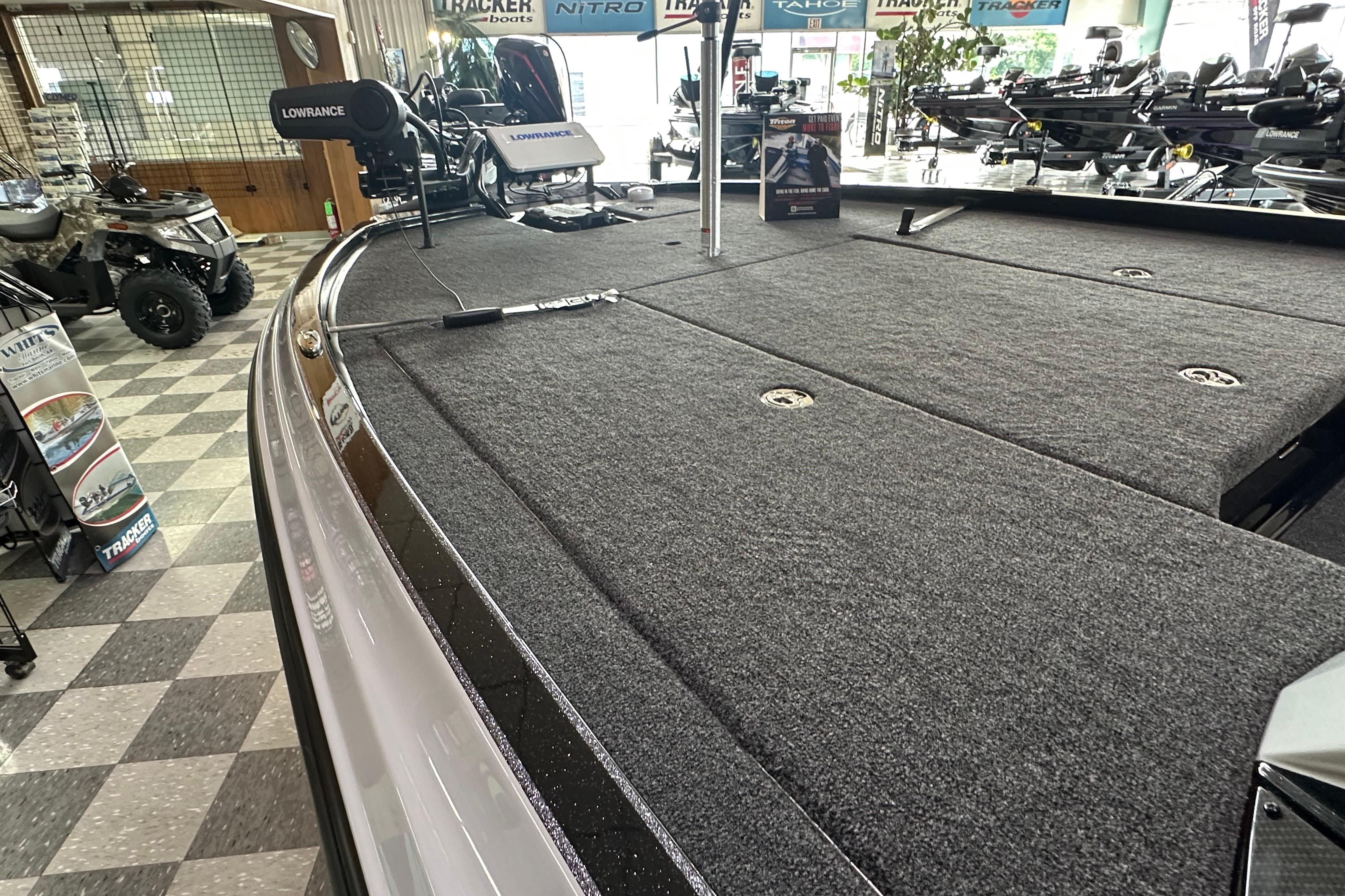 2024 Triton 20XP Patriot boat deck with Lowrance equipment in showroom.