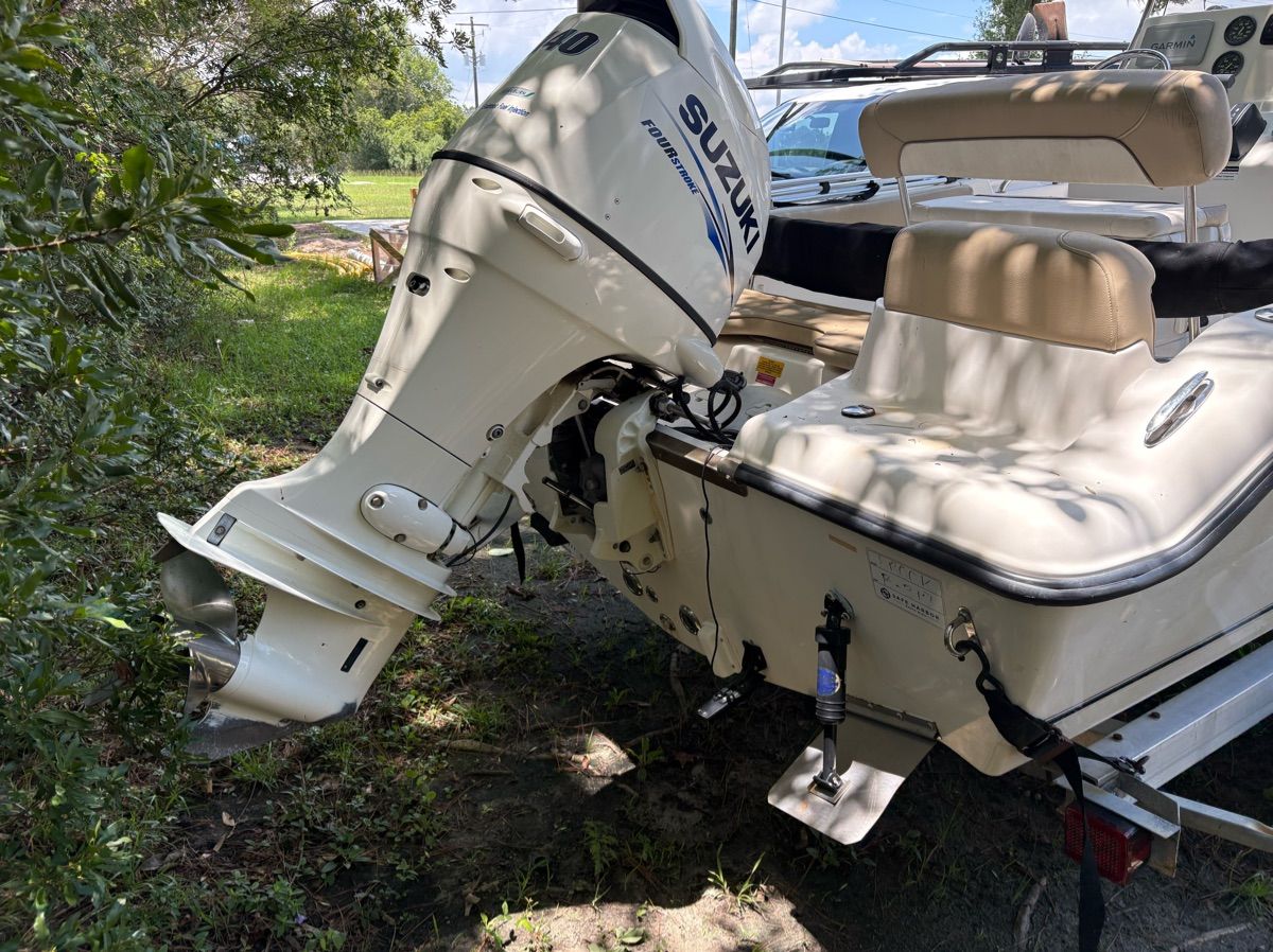 A 2016 Key West 189 FS boat with a Suzuki outboard motor, parked in a grassy area.