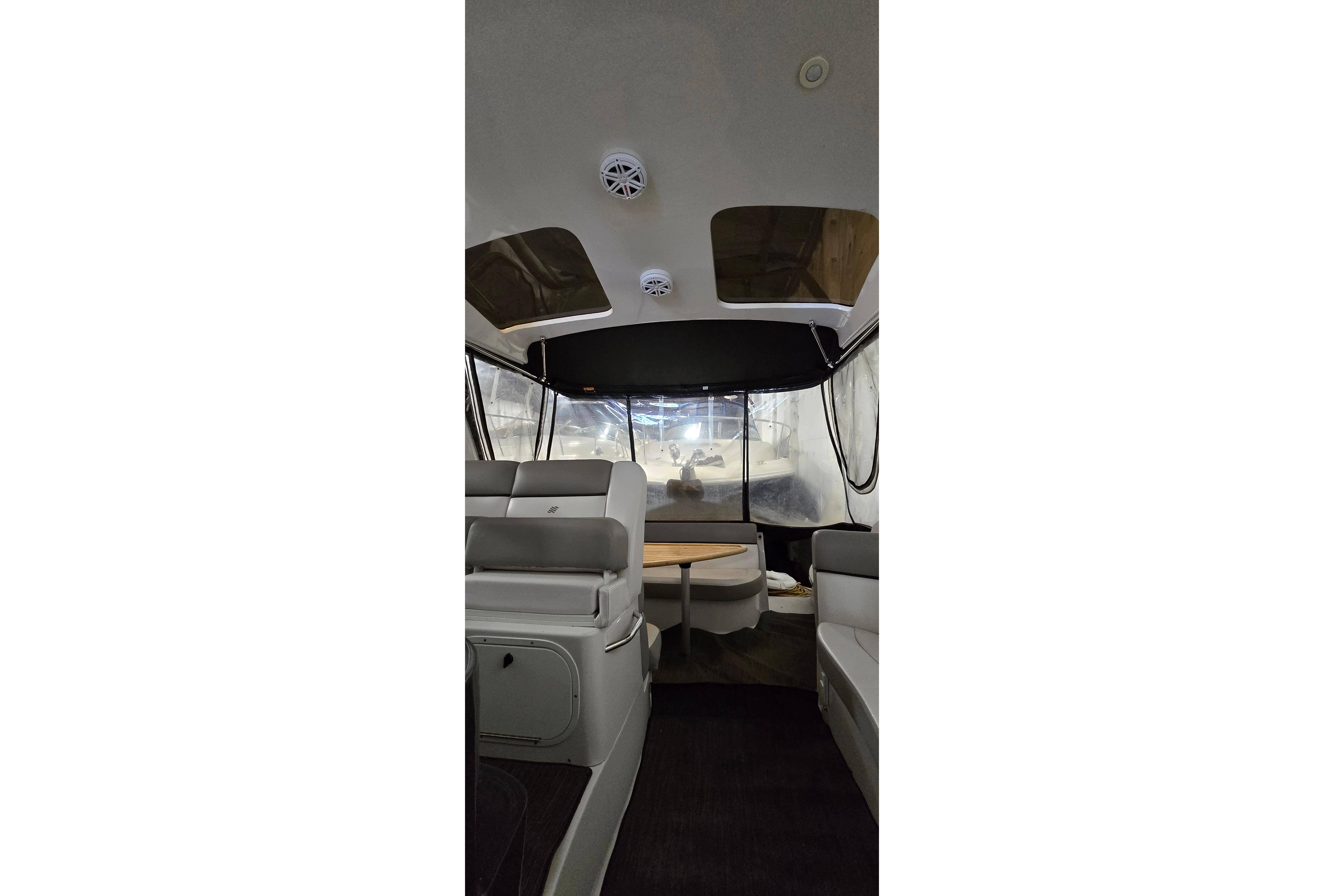 Interior view of 2018 Four Winns V355 boat with seating and table.