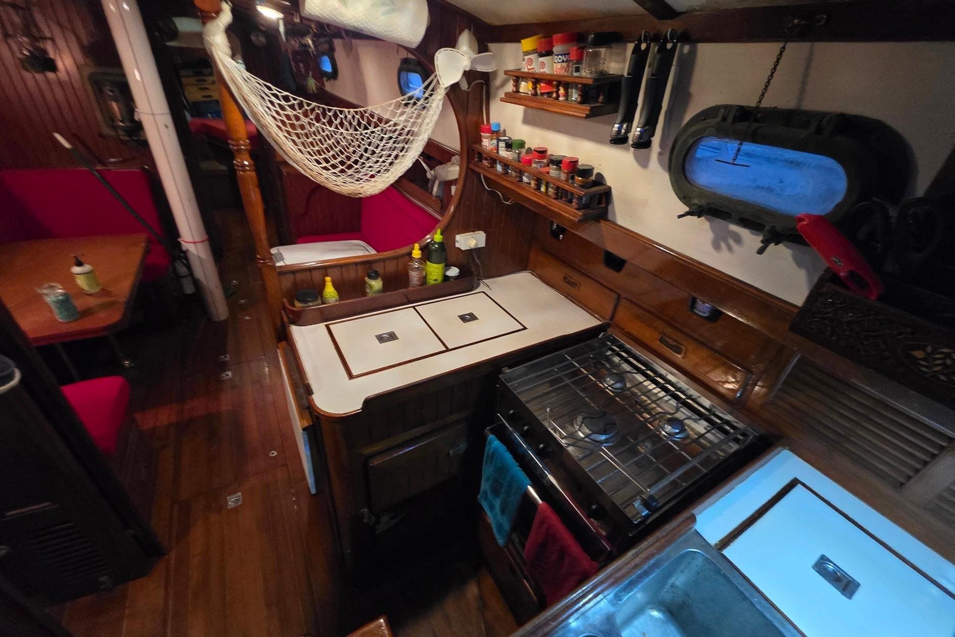 Cozy 1982 Tayana 37 yacht interior with kitchen, dining area, and wooden finishes.