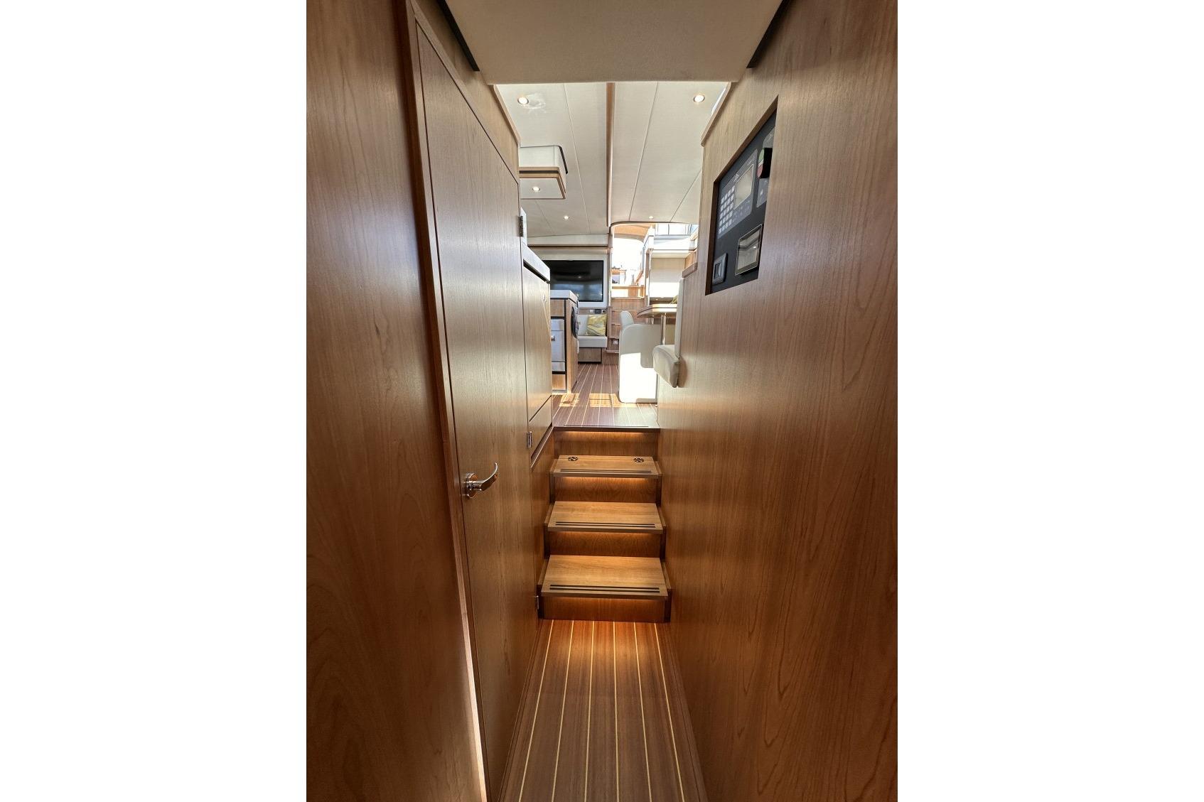 Interior view of 2026 Linssen Grand Sturdy 550 Variotop yacht with wooden stairs and paneling.