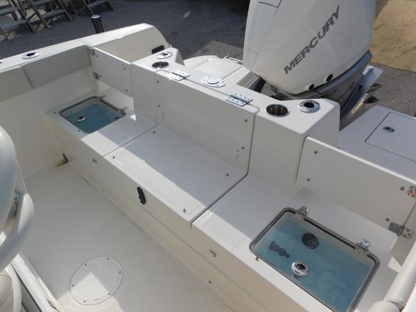 2025 Sailfish 232 CC boat interior with Mercury engine, featuring storage and seating areas.