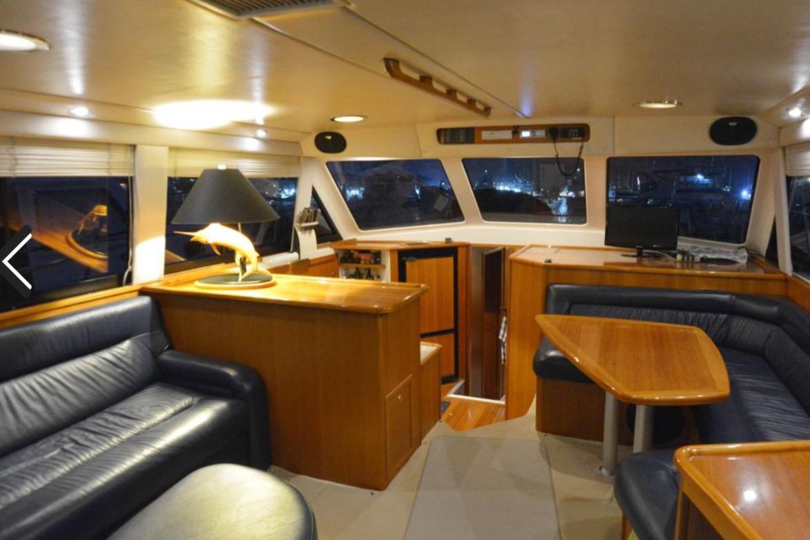 Luxurious interior of 2000 Riviera 48 Enclosed Flybridge with leather seating and wooden finishes.