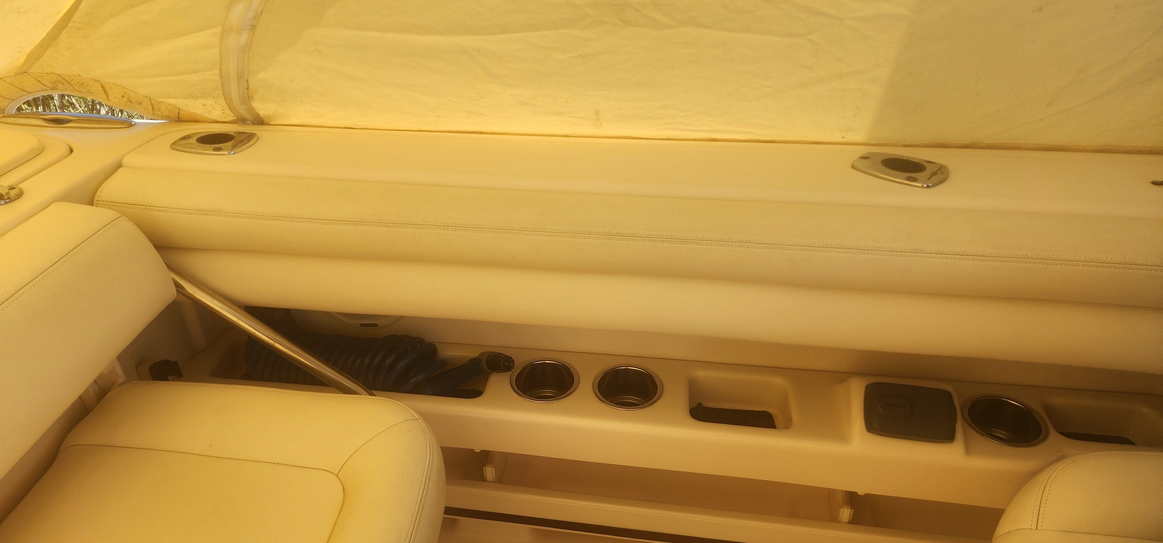 Interior view of a Grady-White Freedom 275 boat with beige seating and cup holders.