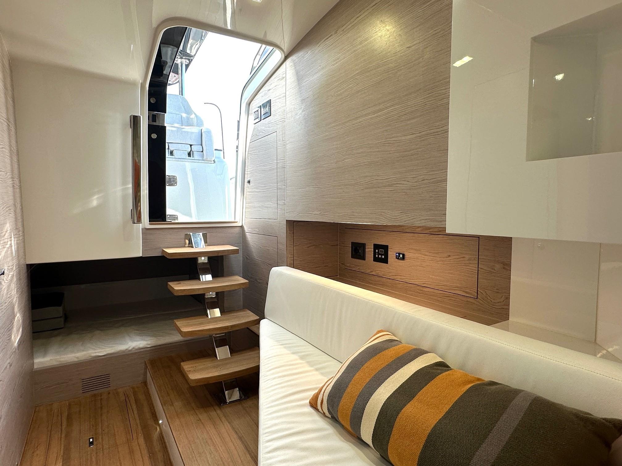 Interior of 2023 SACS Rebel 47 yacht with modern design and wooden stairs.