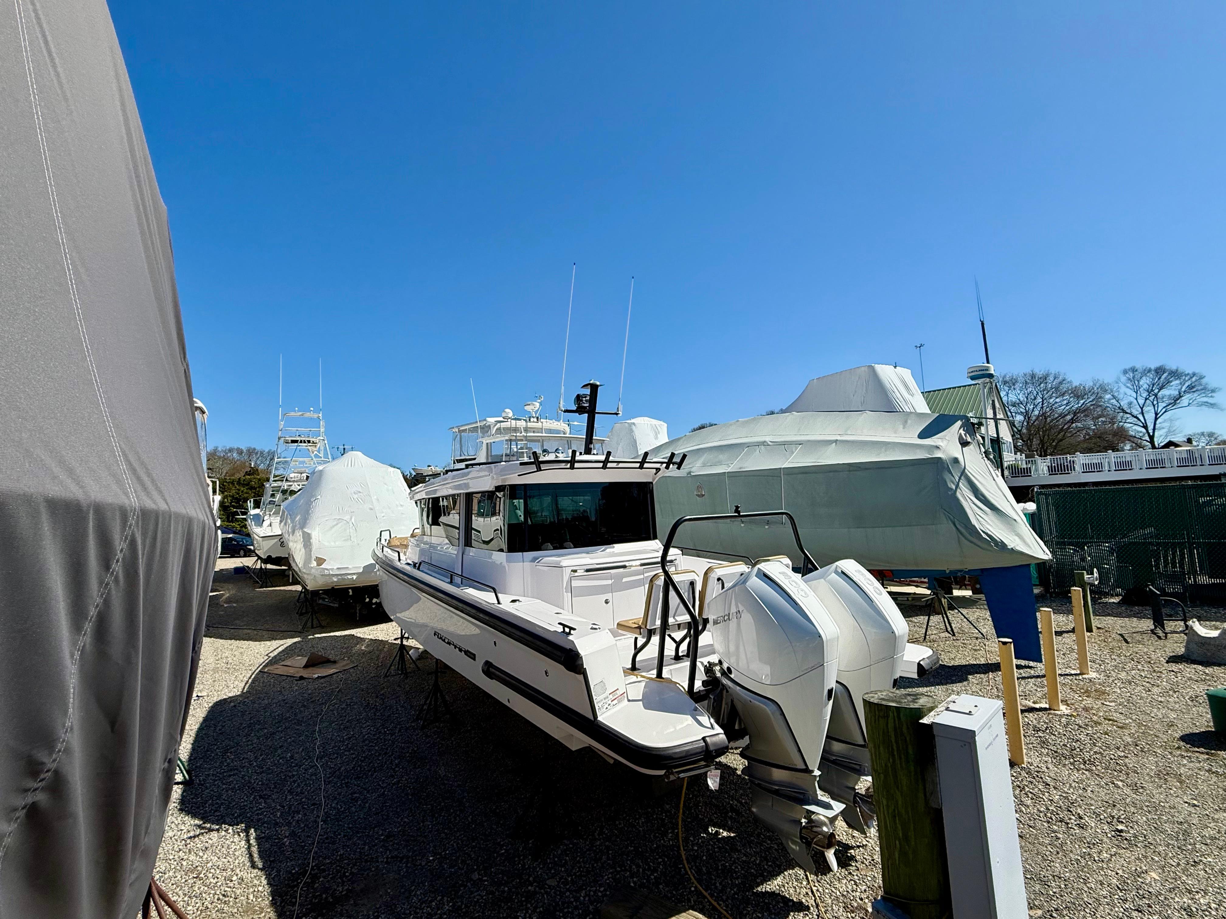 2021 Axopar 37 boat in storage yard under clear blue sky.