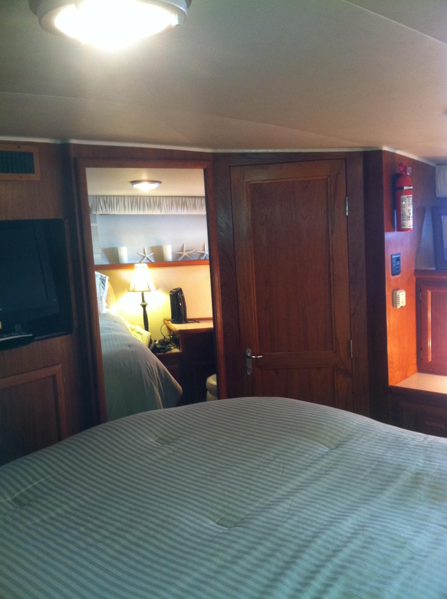 Interior of 1989 Californian 48 Motor Yacht with cozy bedroom and wooden furnishings.