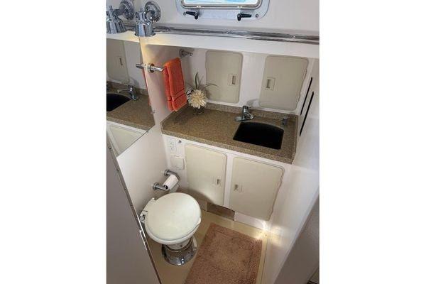 Compact bathroom in 2011 Reliance 44 yacht with sink, toilet, and storage cabinets.