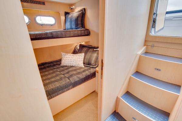 Interior of 2006 Horizon 82’ Cockpit Motoryacht with bunk beds and stairs.