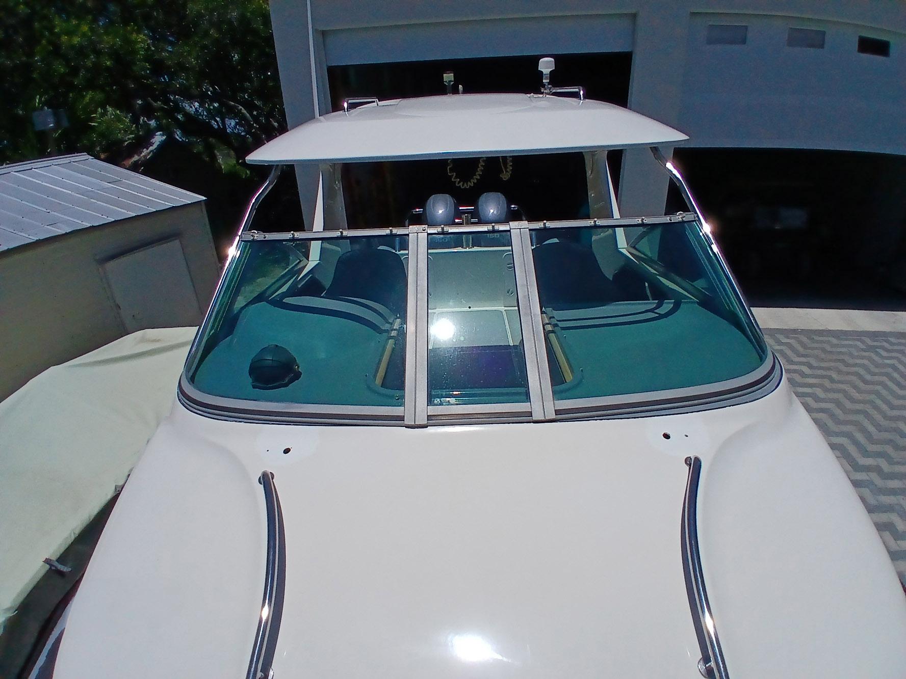 2002 Protector 28 Targa boat with sleek windshield and modern design in a driveway.
