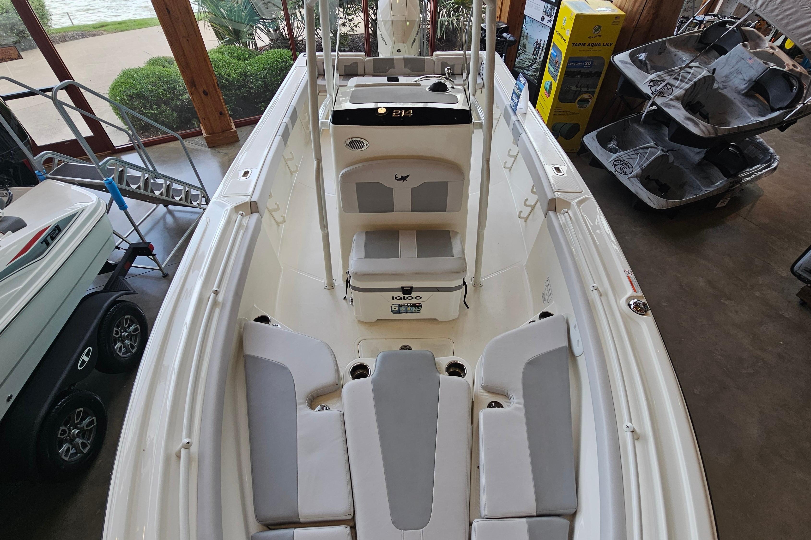 2025 Mako 214 Center Console boat interior with seating and storage, displayed indoors.